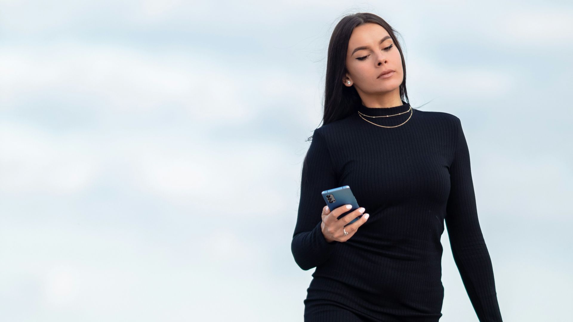 woman in black long sleeve shirt and black shorts holding black leather handbag
