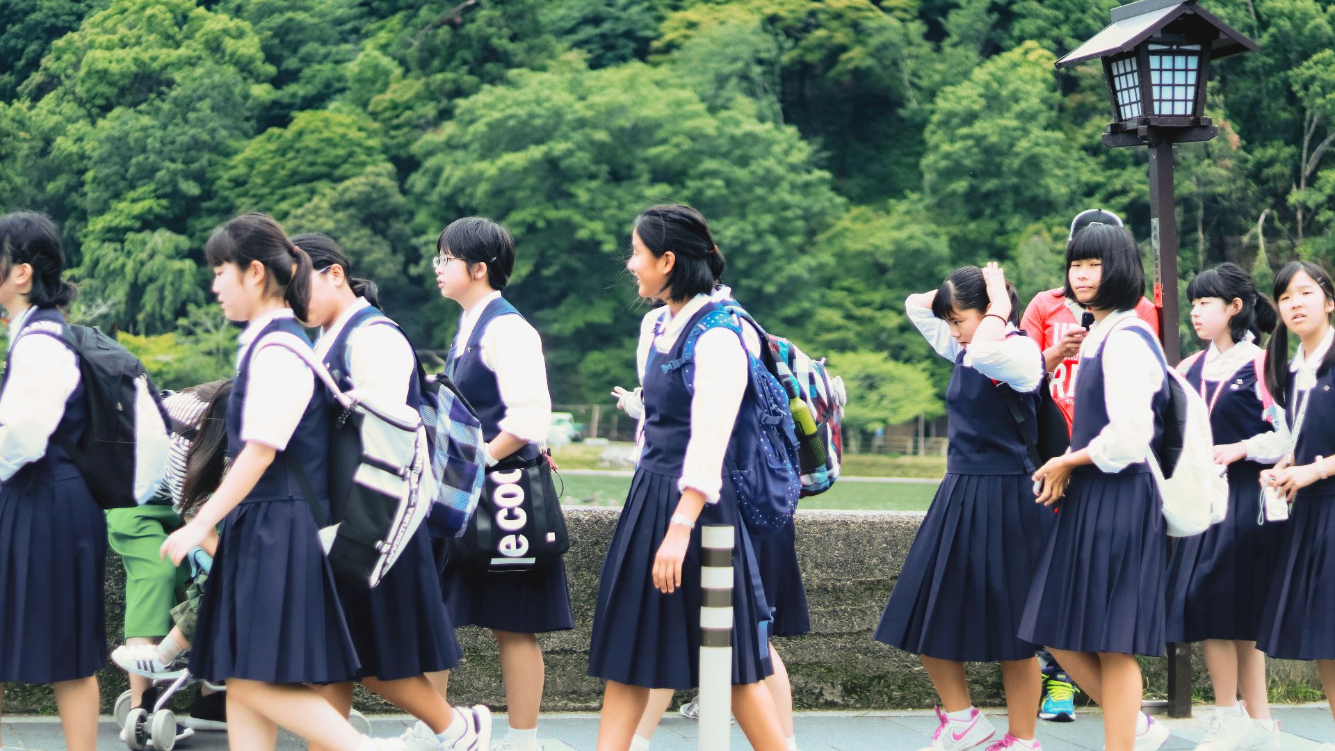 group of women in school uniform standing on green grass field during daytime