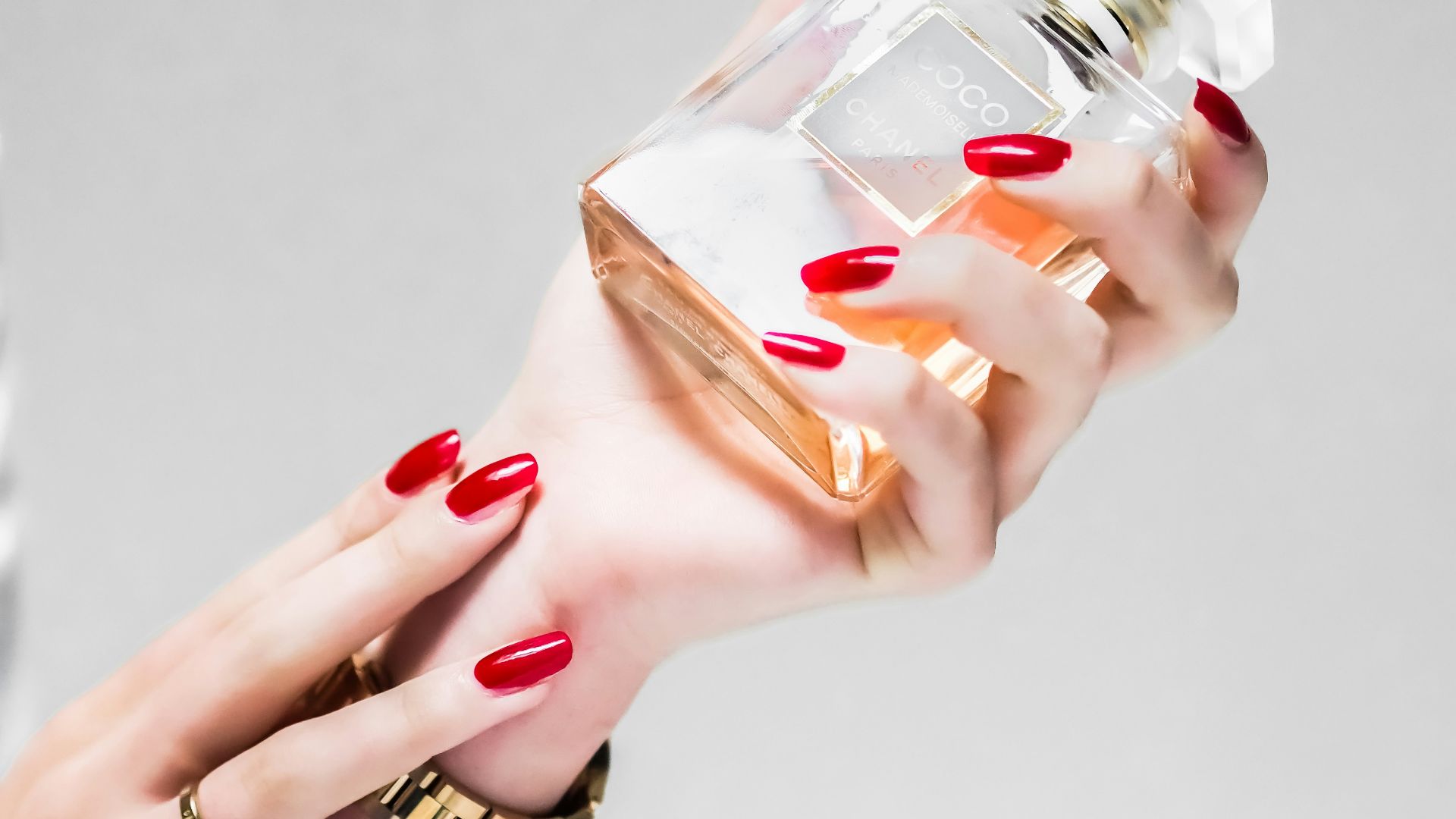 person holding clear glass bottle