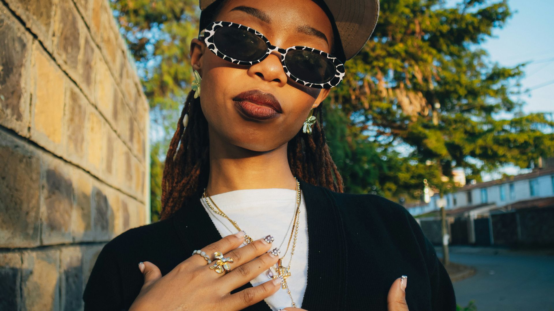 Young woman wearing sunglasses and a baseball cap.