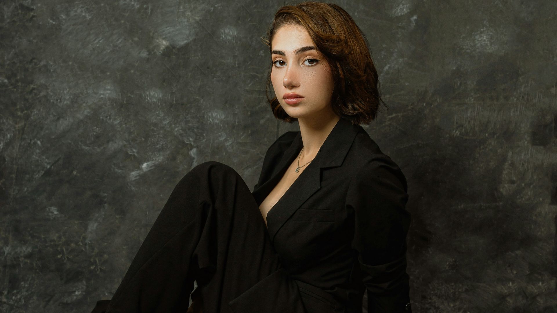 a woman sitting on the ground in a black dress