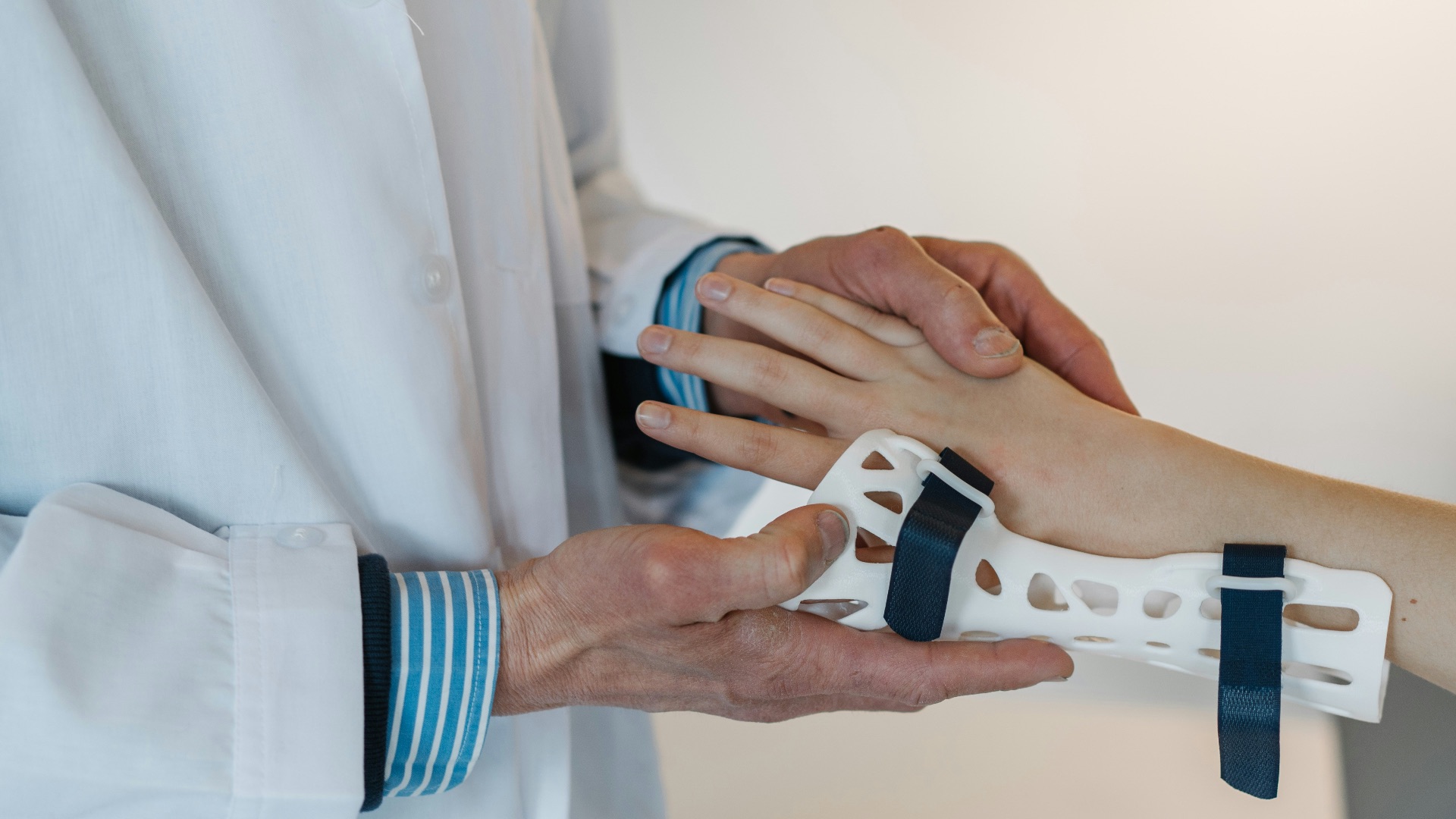 person in white coat holding silver and blue ring