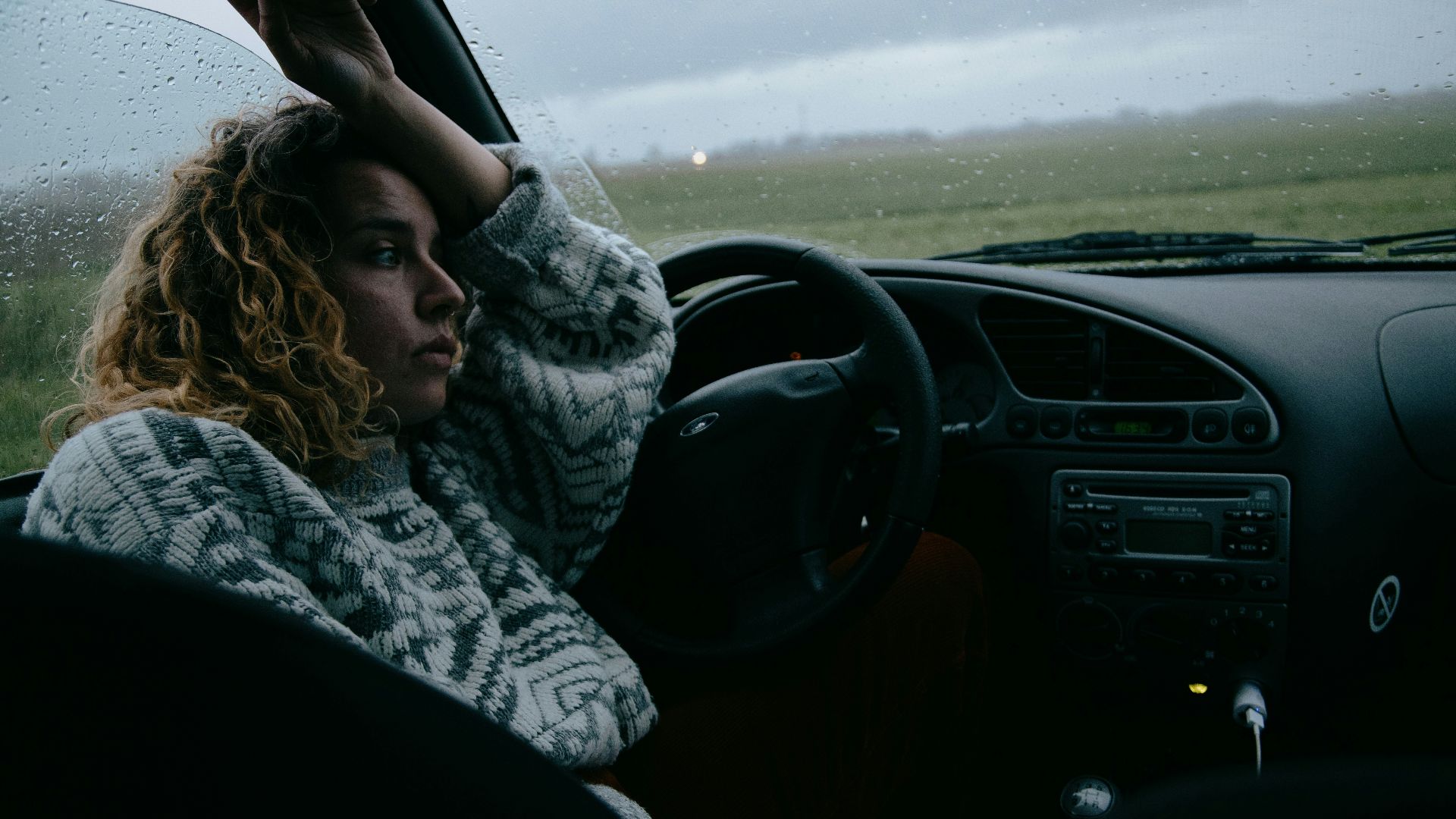 woman in black and white scarf driving car