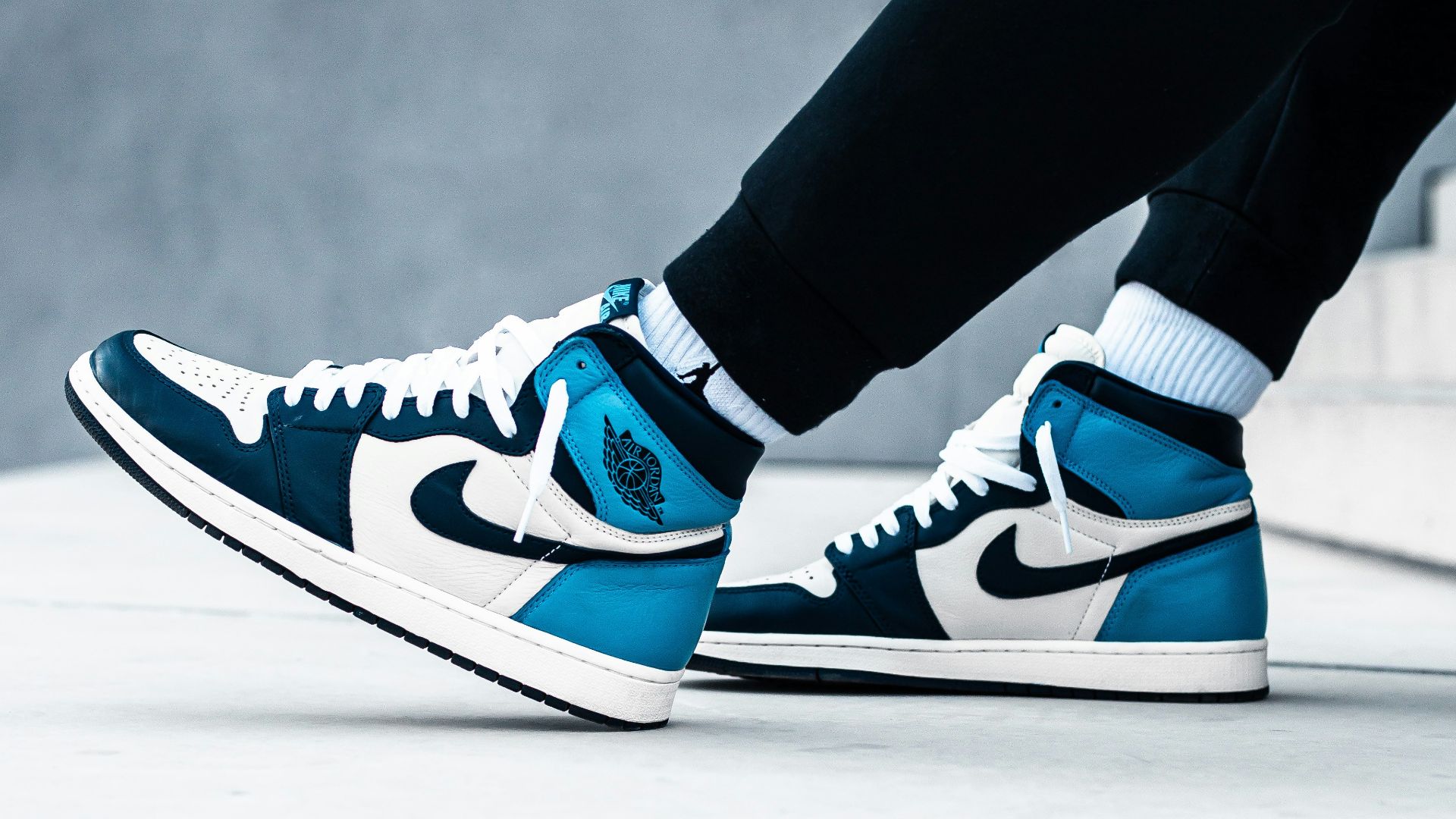 person wearing black pants and blue and white nike sneakers