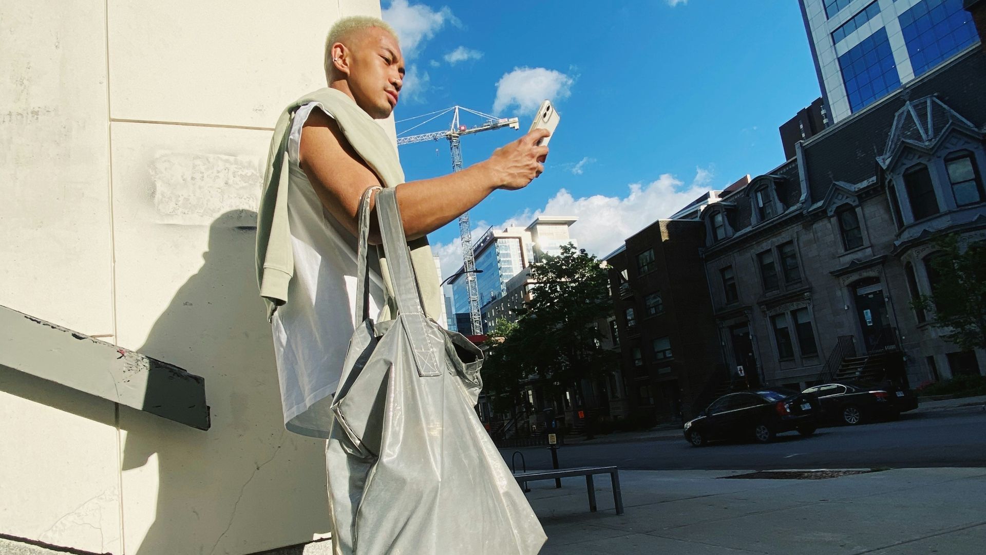 woman in white coat and blue denim jeans standing on gray concrete pavement during daytime