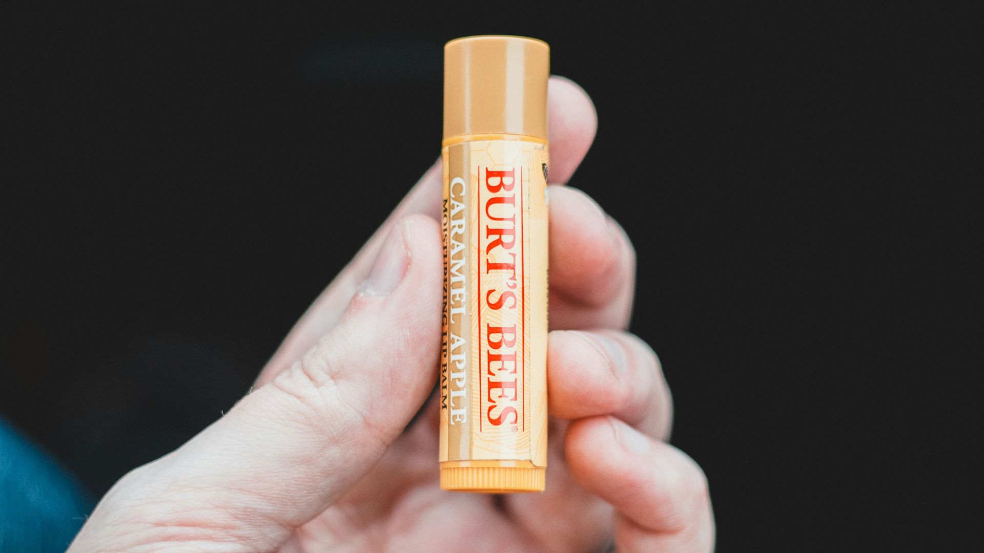 person holding orange and yellow plastic tube