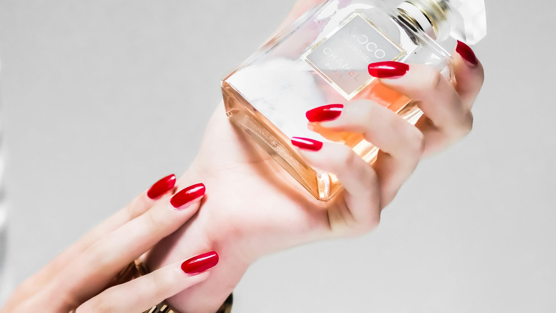 person holding clear glass bottle