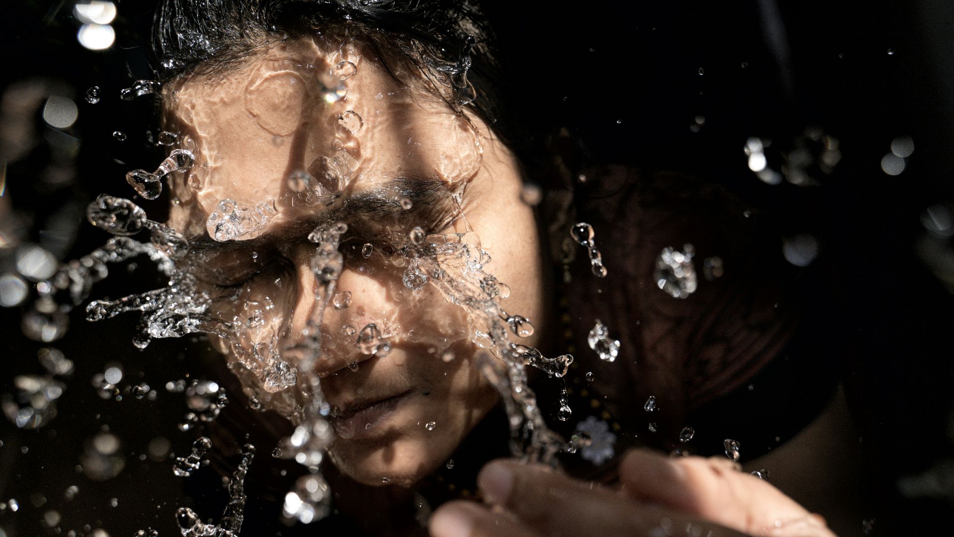 woman in black shirt with water droplets