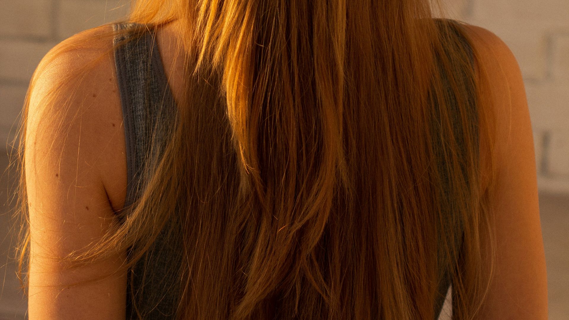 woman in black tank top with brown hair tie