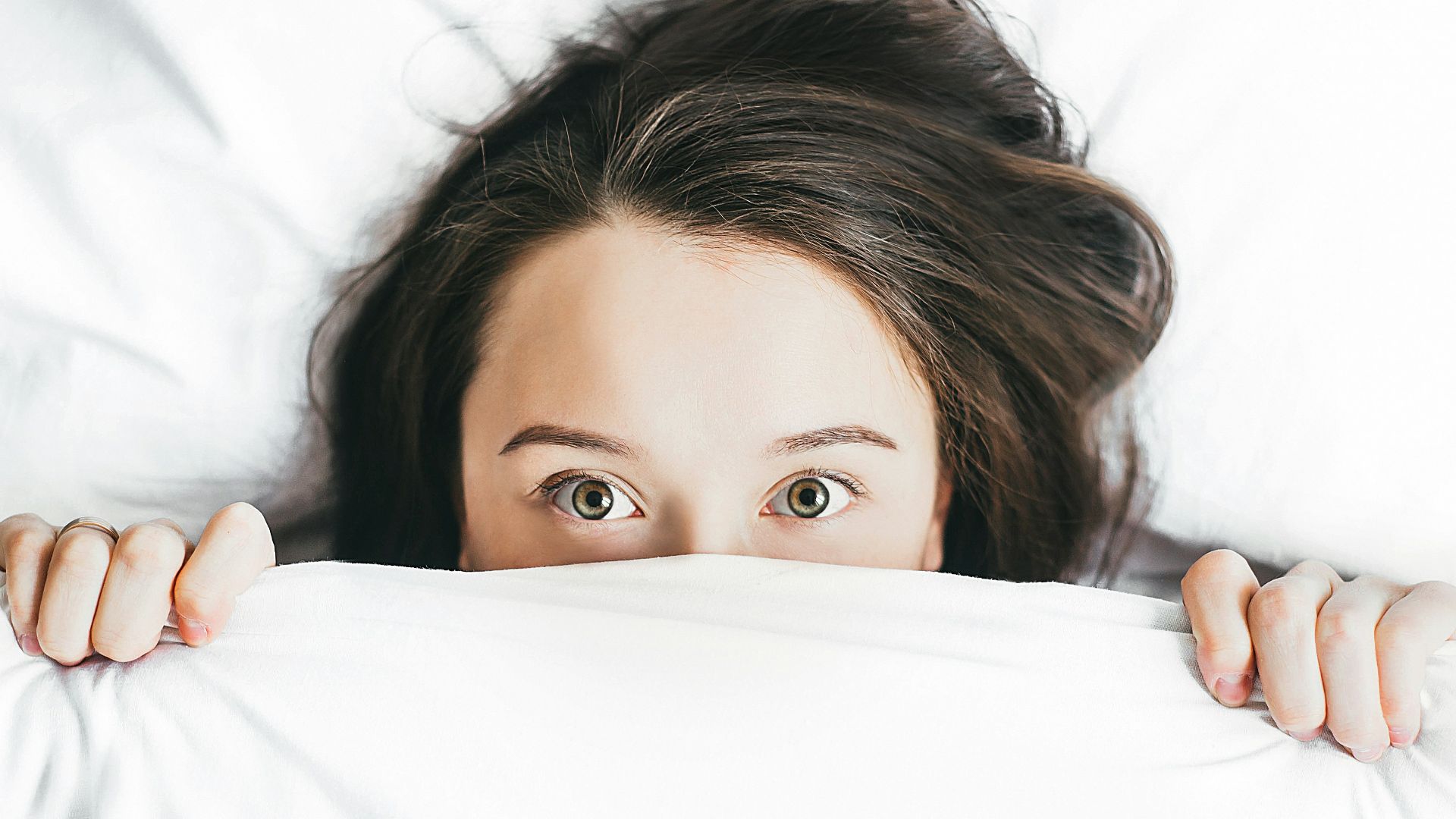 woman covering her face with blanket