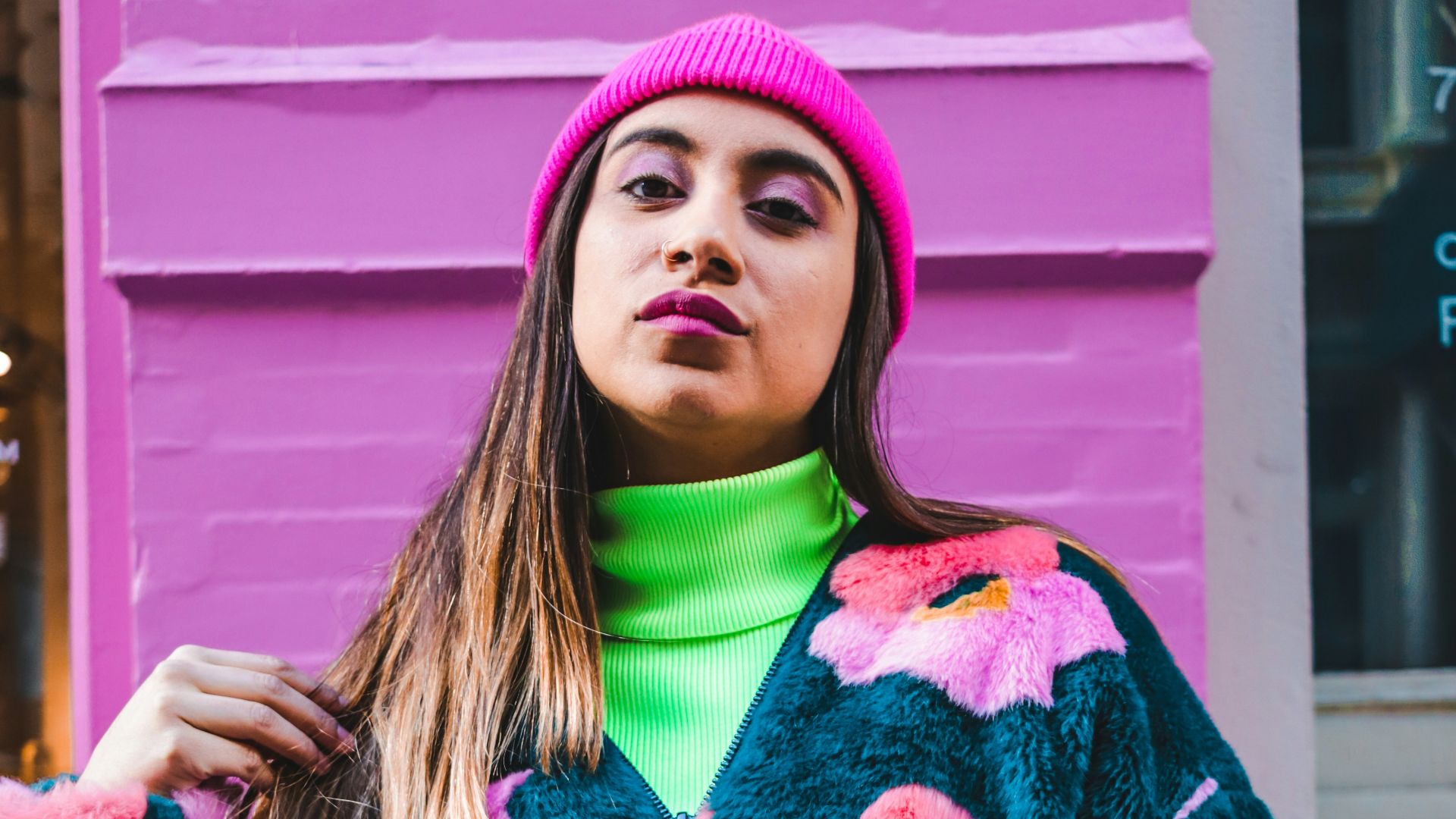 woman in red and white sweater wearing pink knit cap
