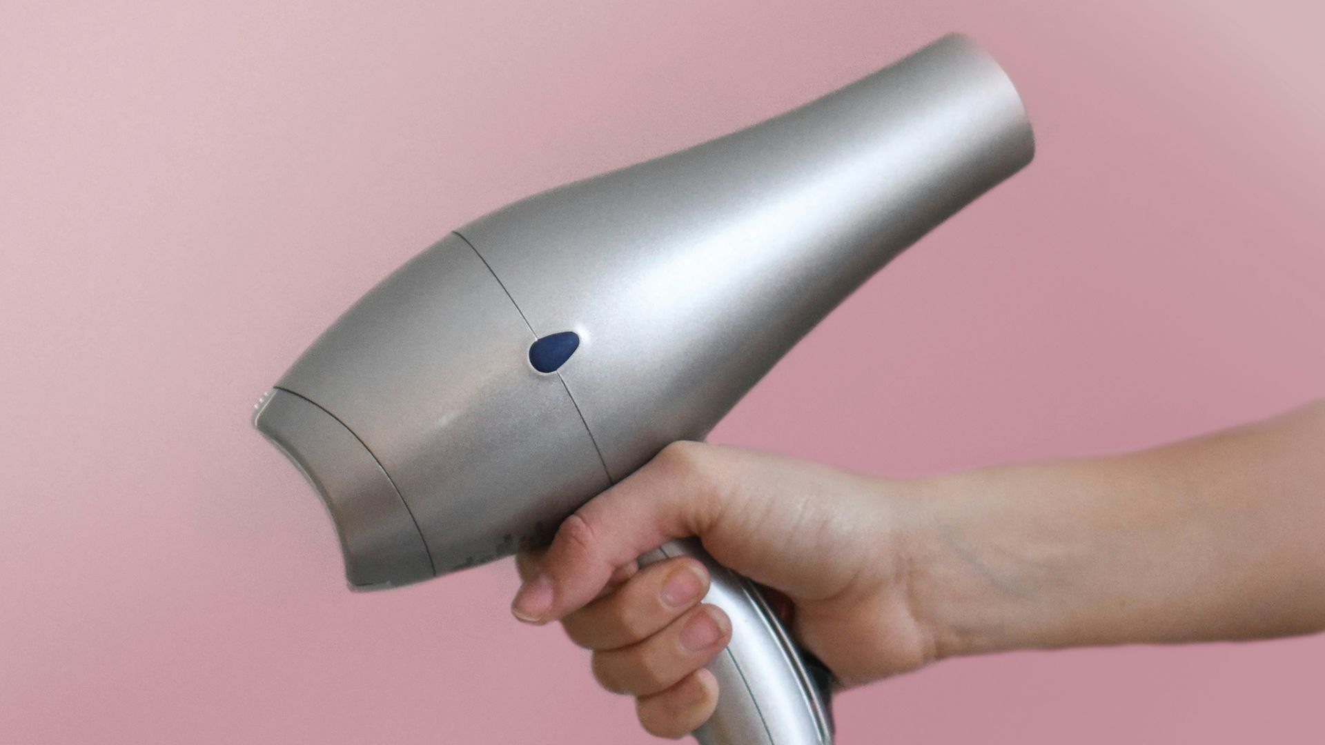 person holding gray corded hair dryer