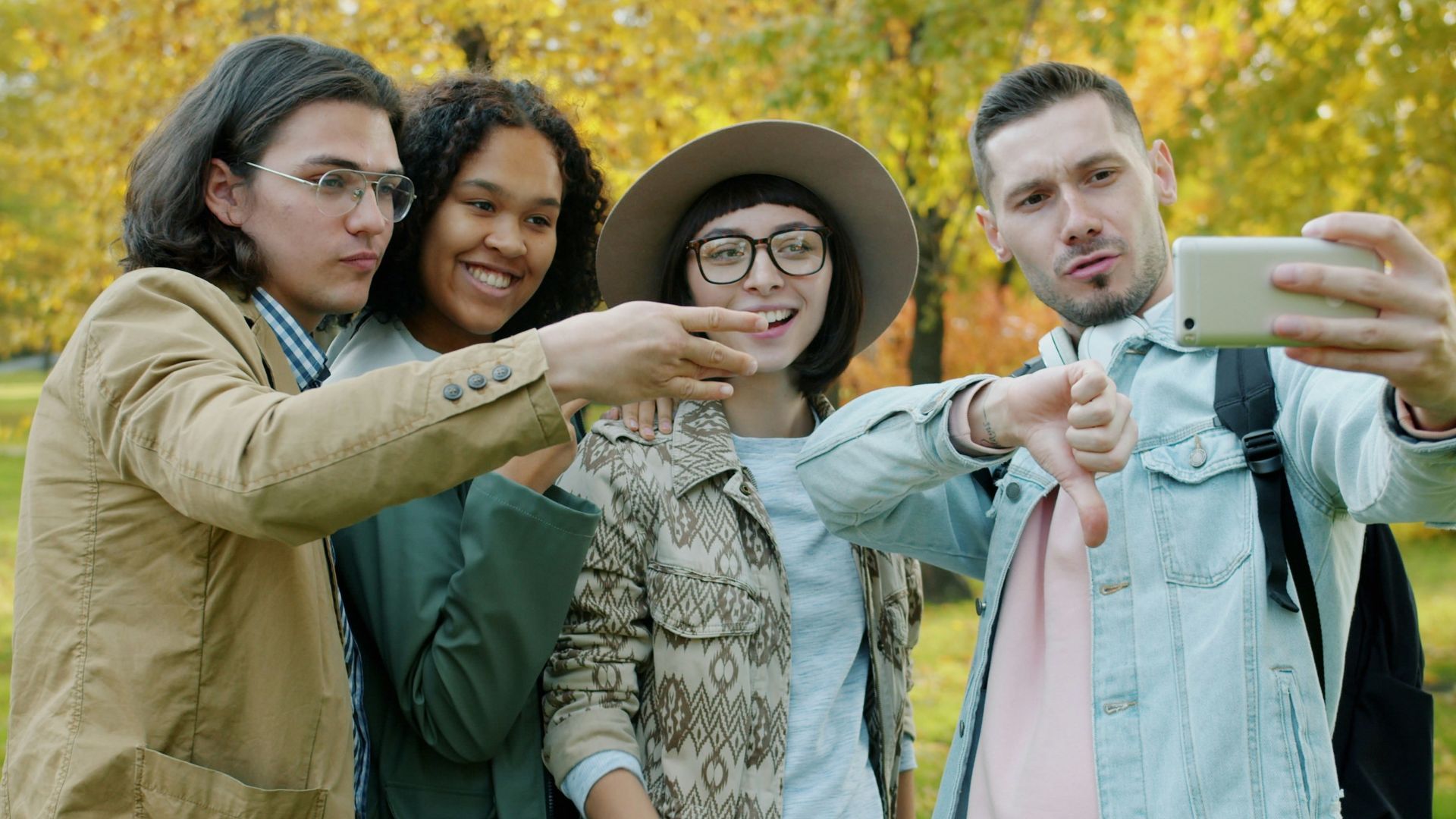 Four friends taking a selfie in a park.