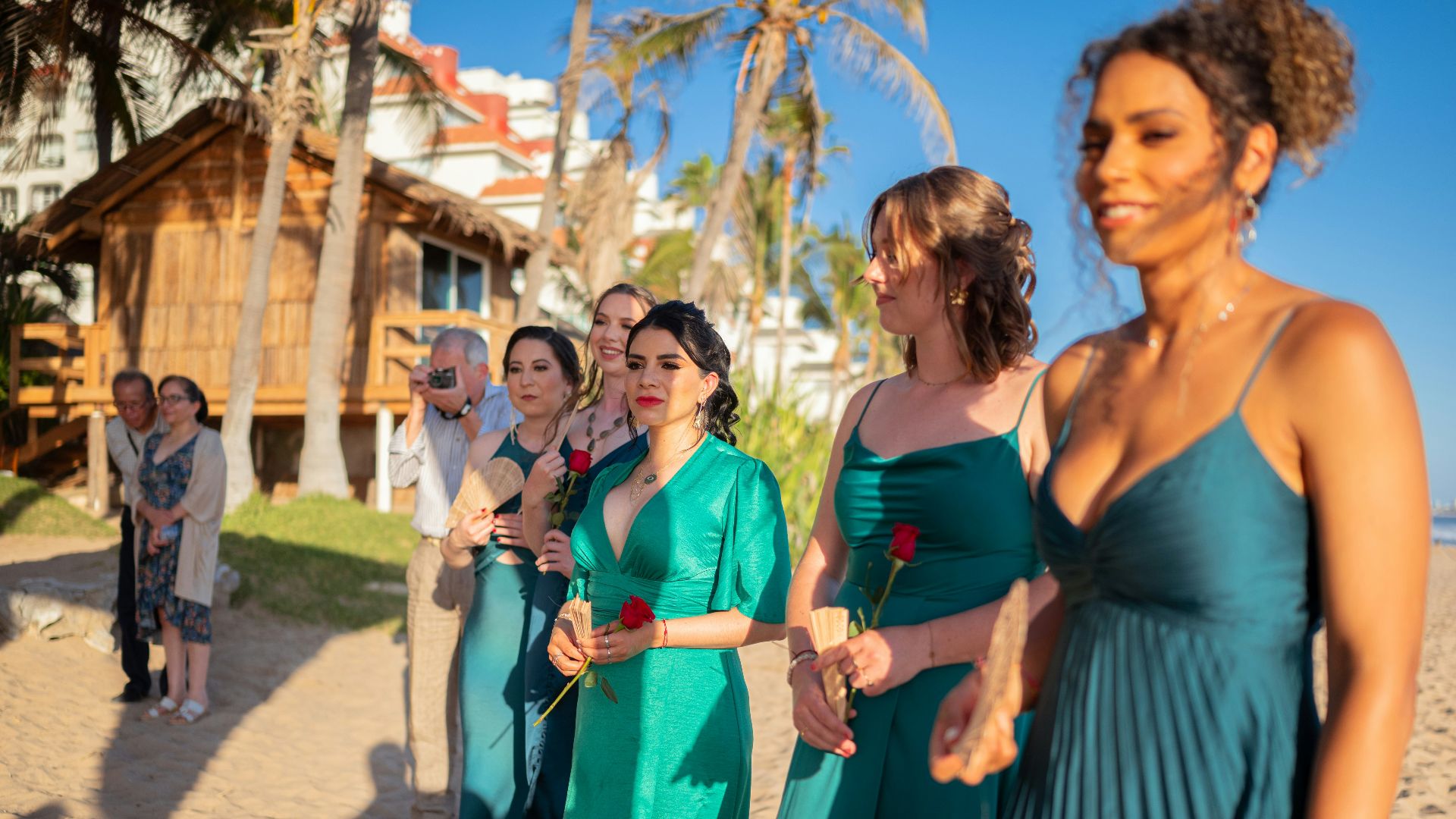 Wedding party standing on a beach with roses