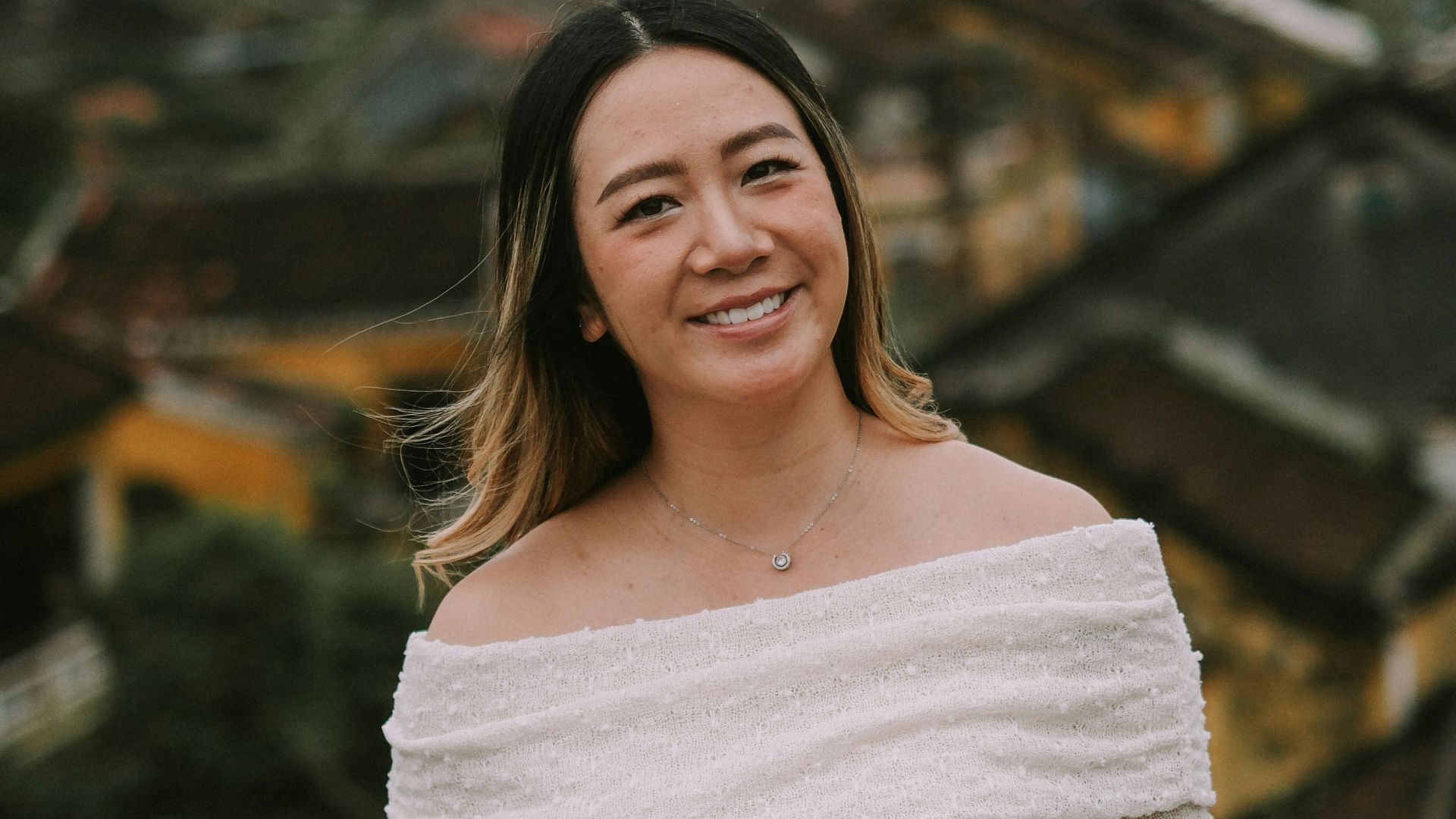 Smiling woman in a white off-the-shoulder dress