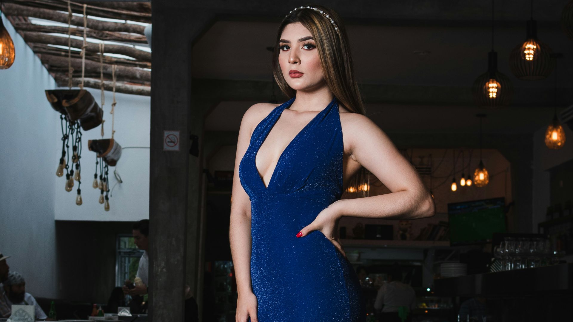 Woman in a sparkly blue gown at a restaurant.