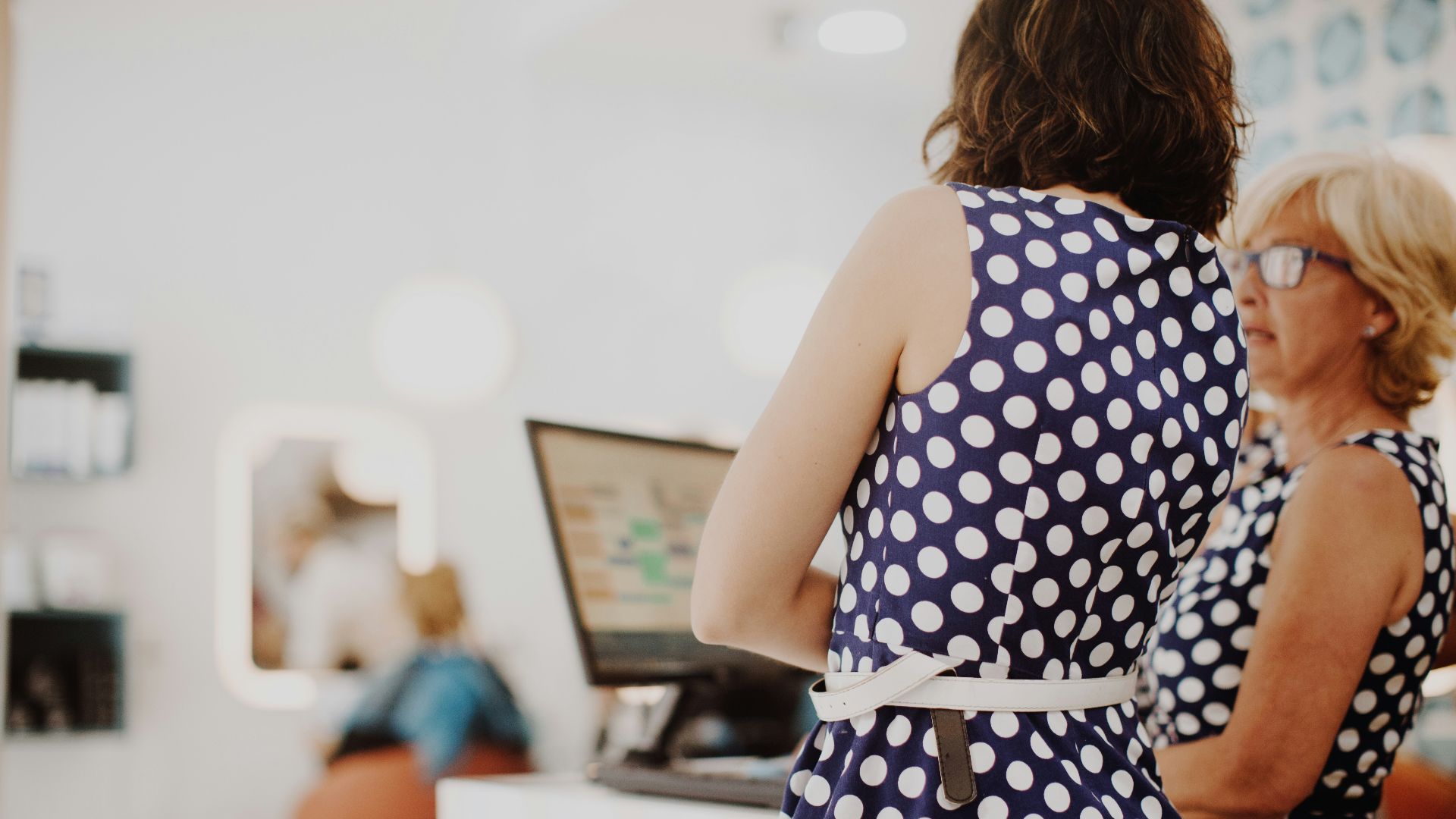 two woman wearing black and white polka-dot sleeveless dresses