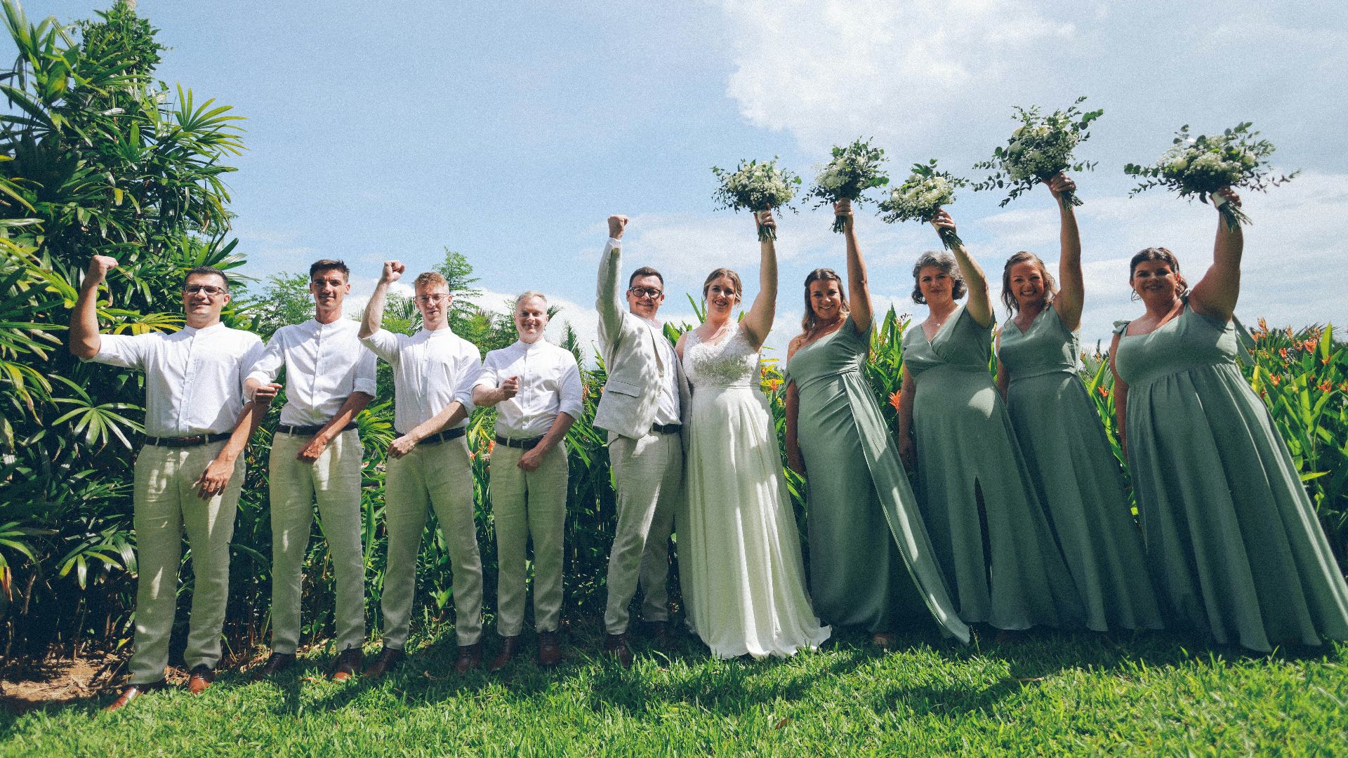 Wedding party celebrating outdoors with bouquets