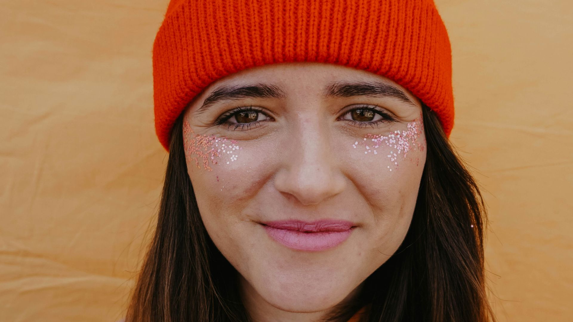 woman in orange knit cap smiling