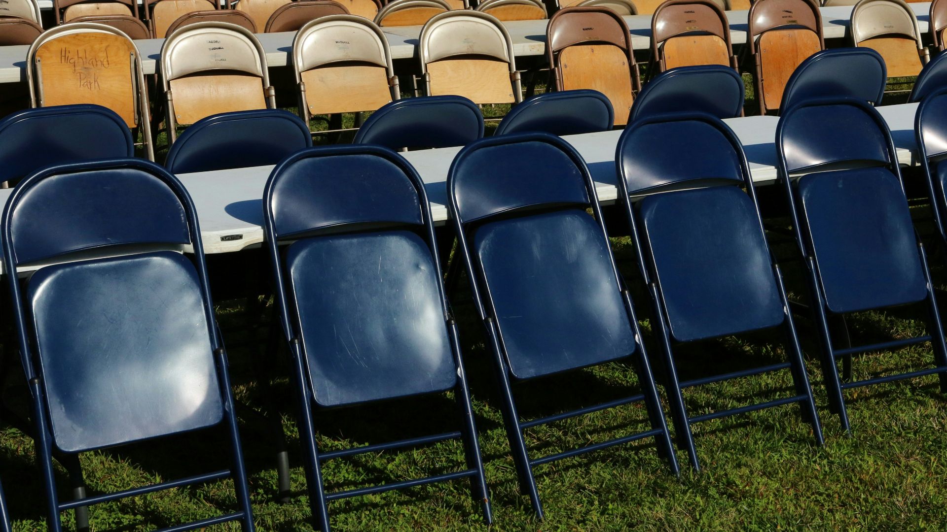 Rows of empty folding chairs on grass