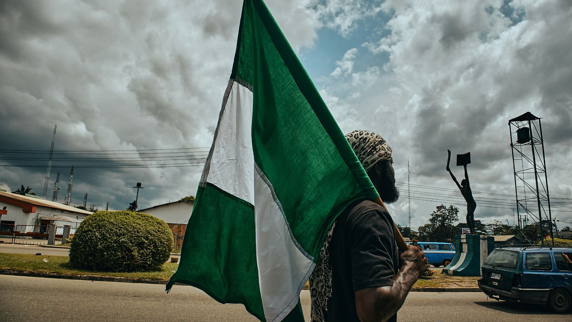 woman in black and white hijab holding green flag