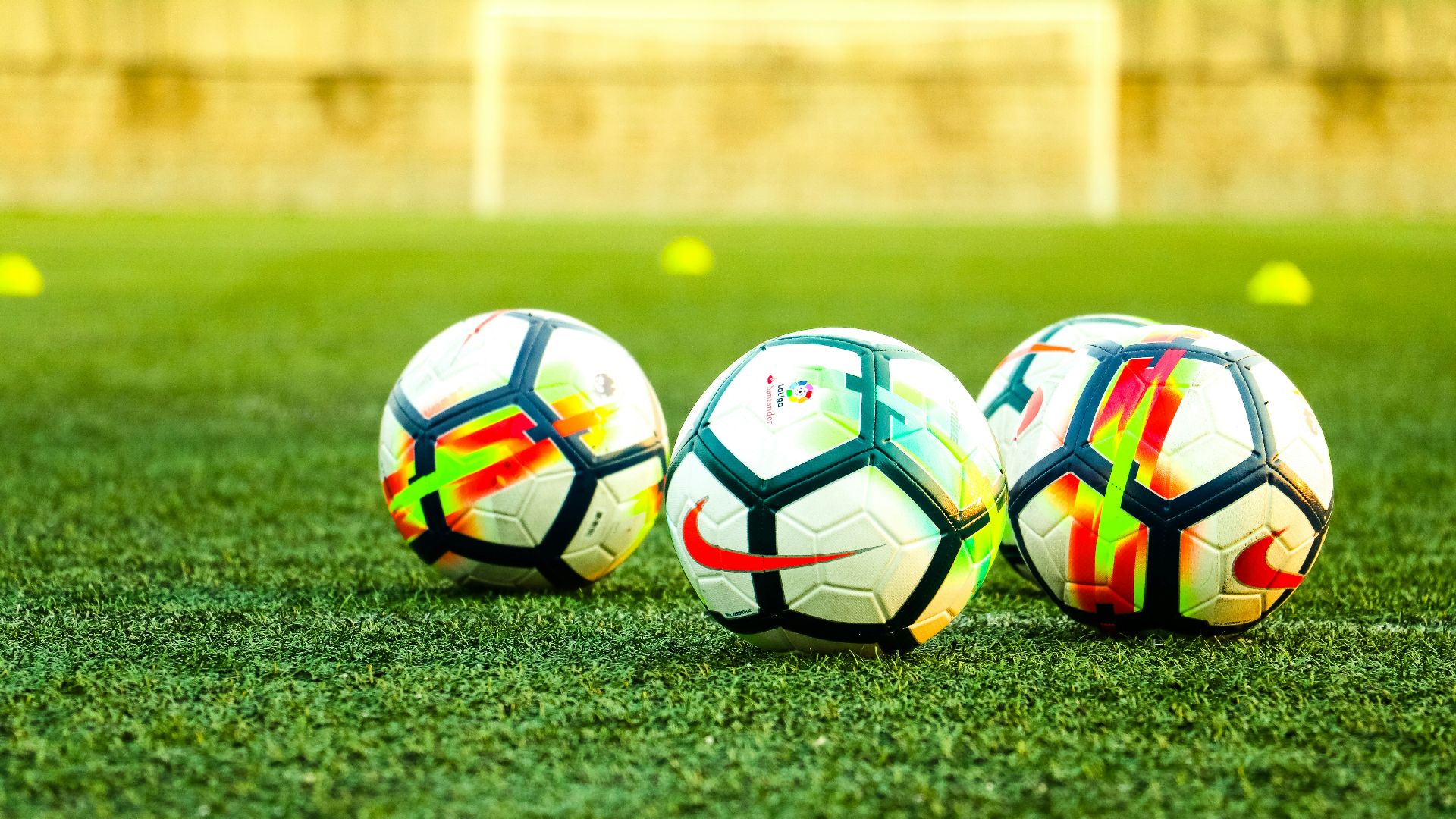 three white-and-black soccer balls on field
