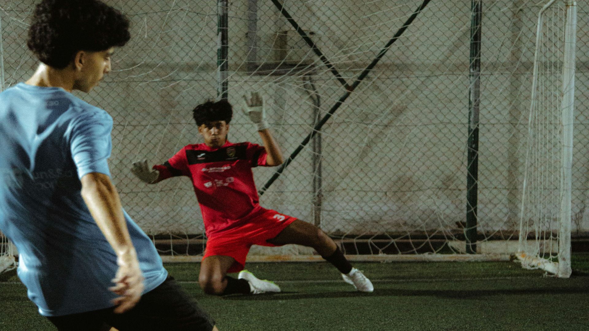 a couple of young men kicking around a soccer ball