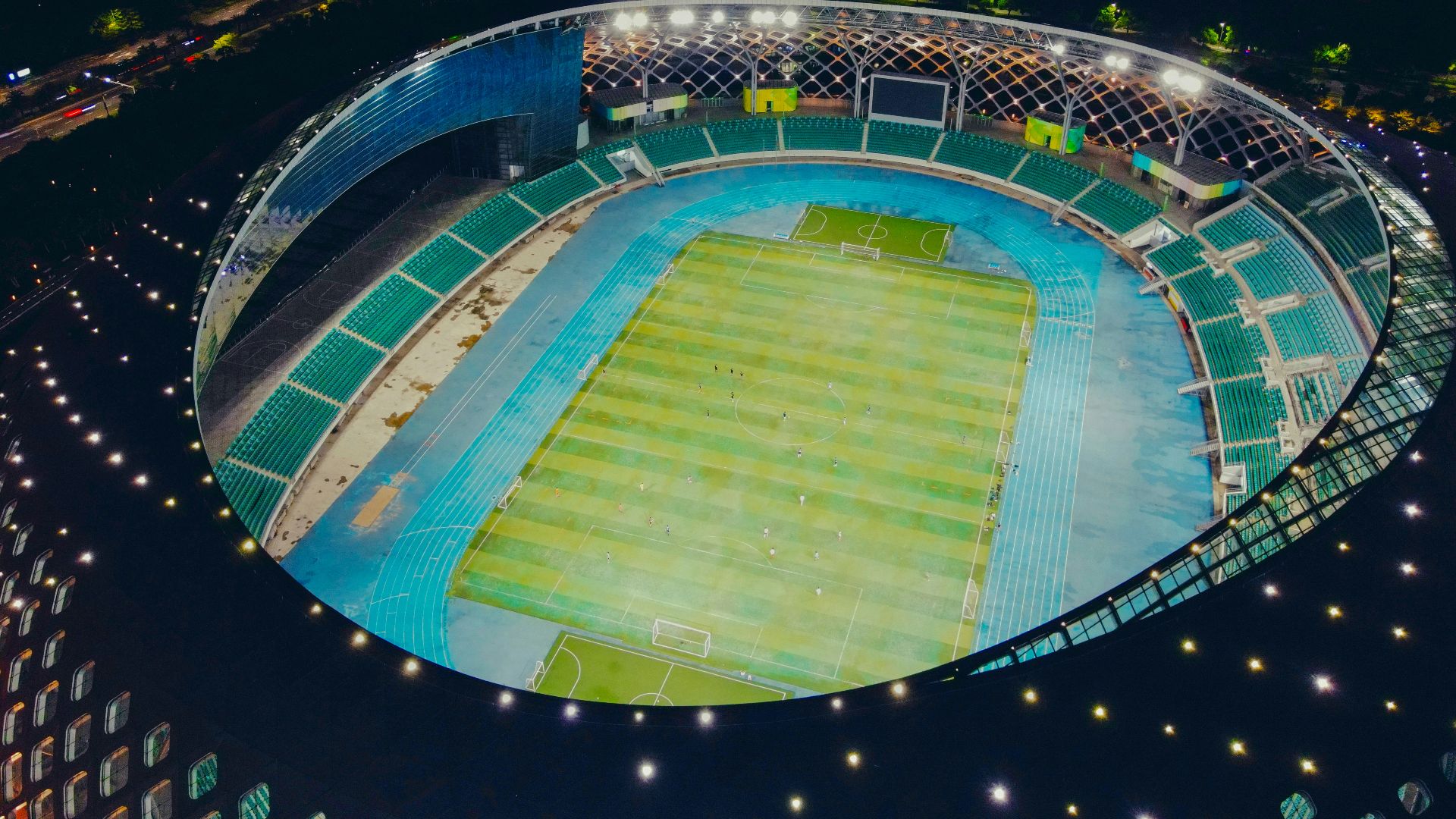 green and blue stadium with lights turned on during night time