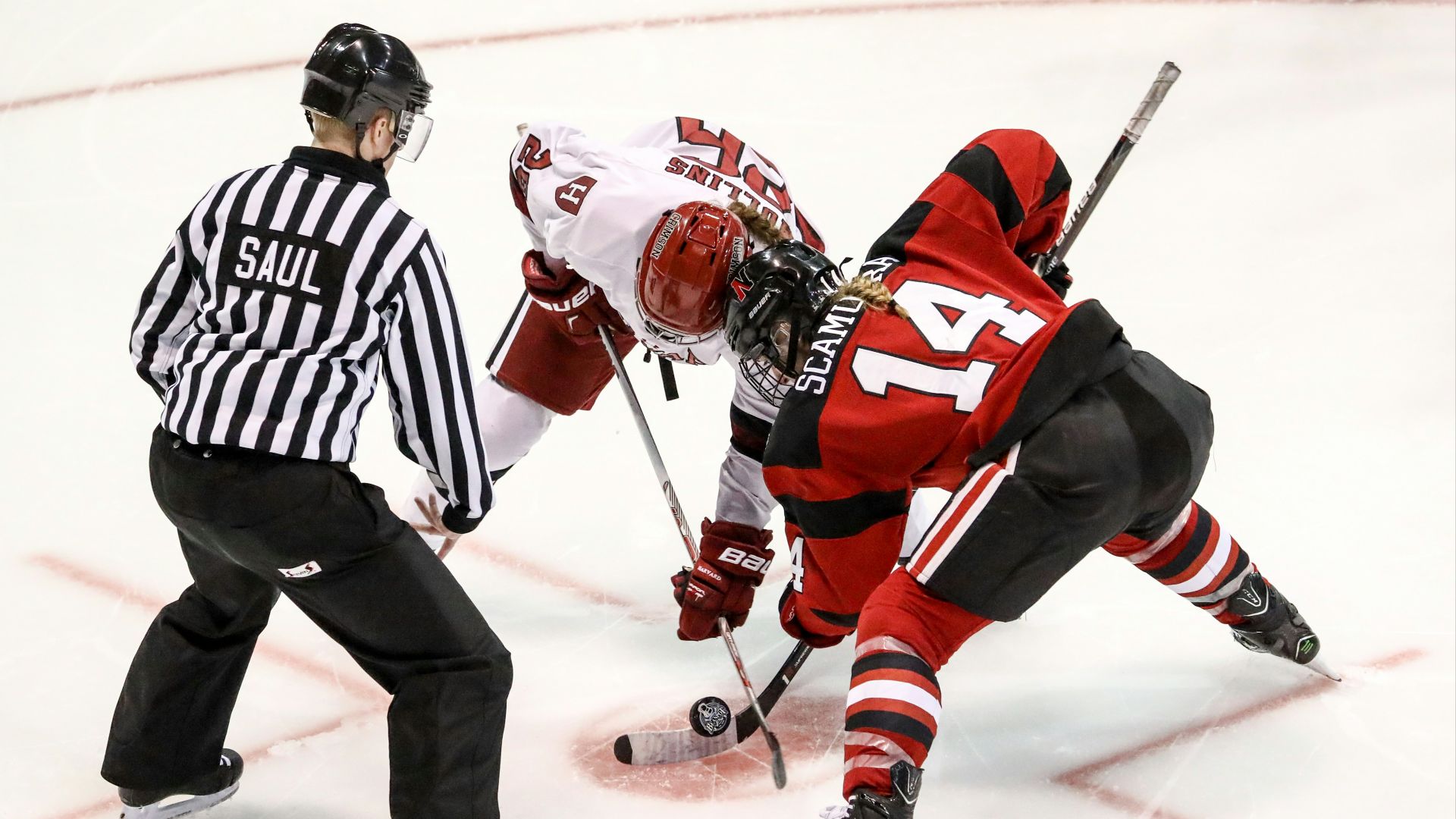 two persons playing ice hockey with referee