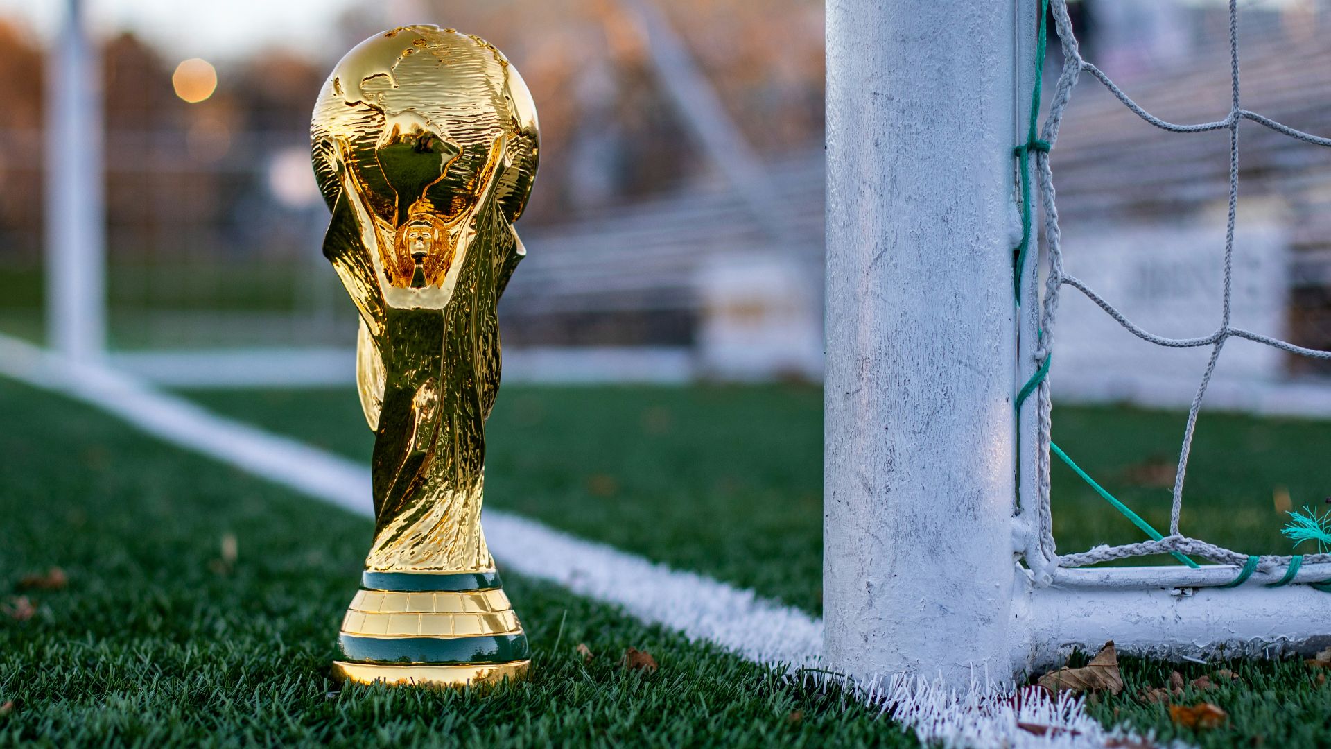 a golden soccer trophy sitting on top of a soccer field