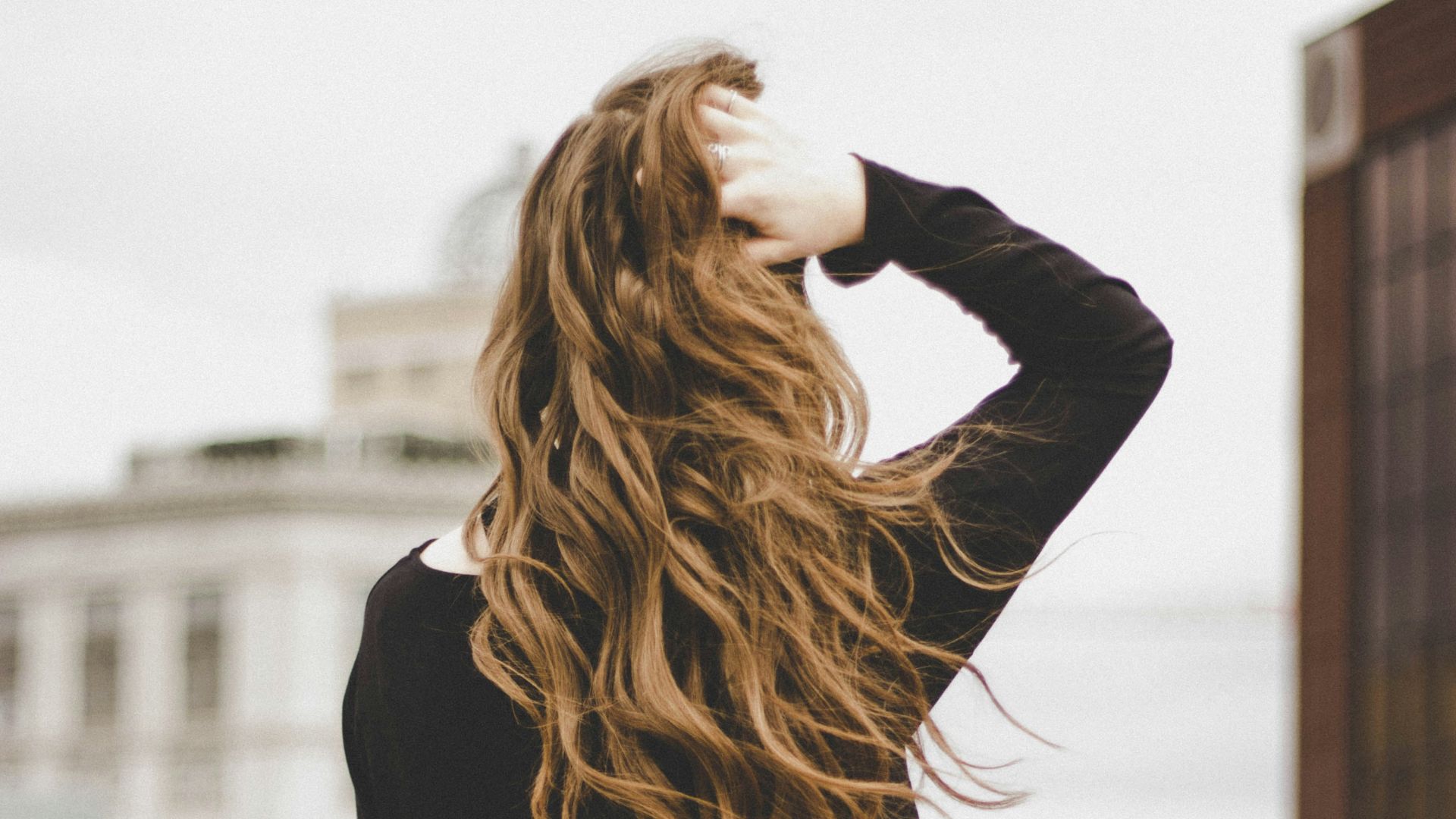 woman sitting while holding her hair