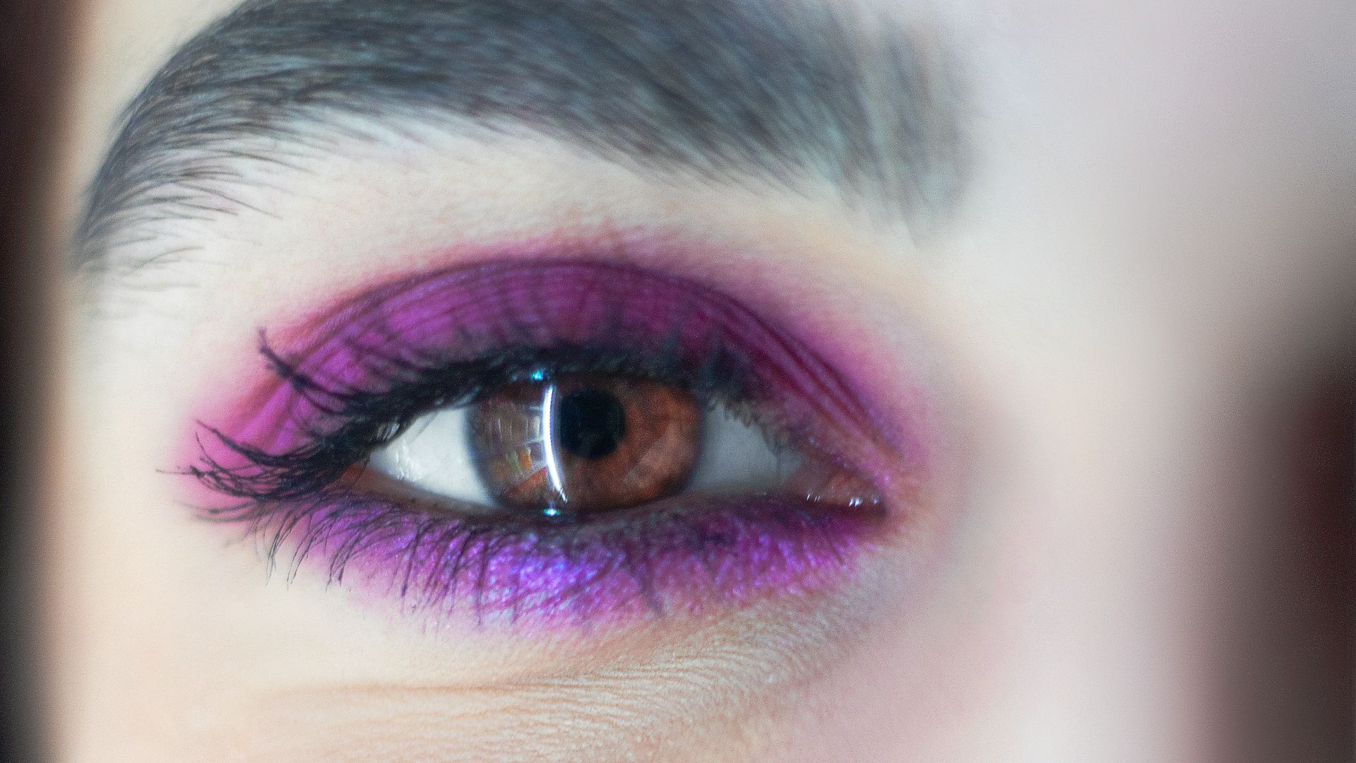 a close up of a woman's face with purple eye makeup