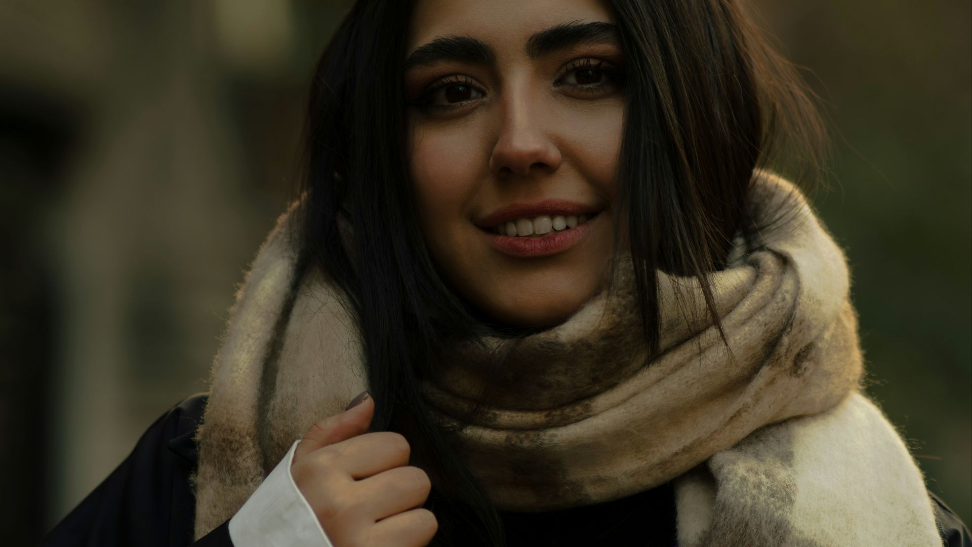 A woman wearing a scarf and a black jacket