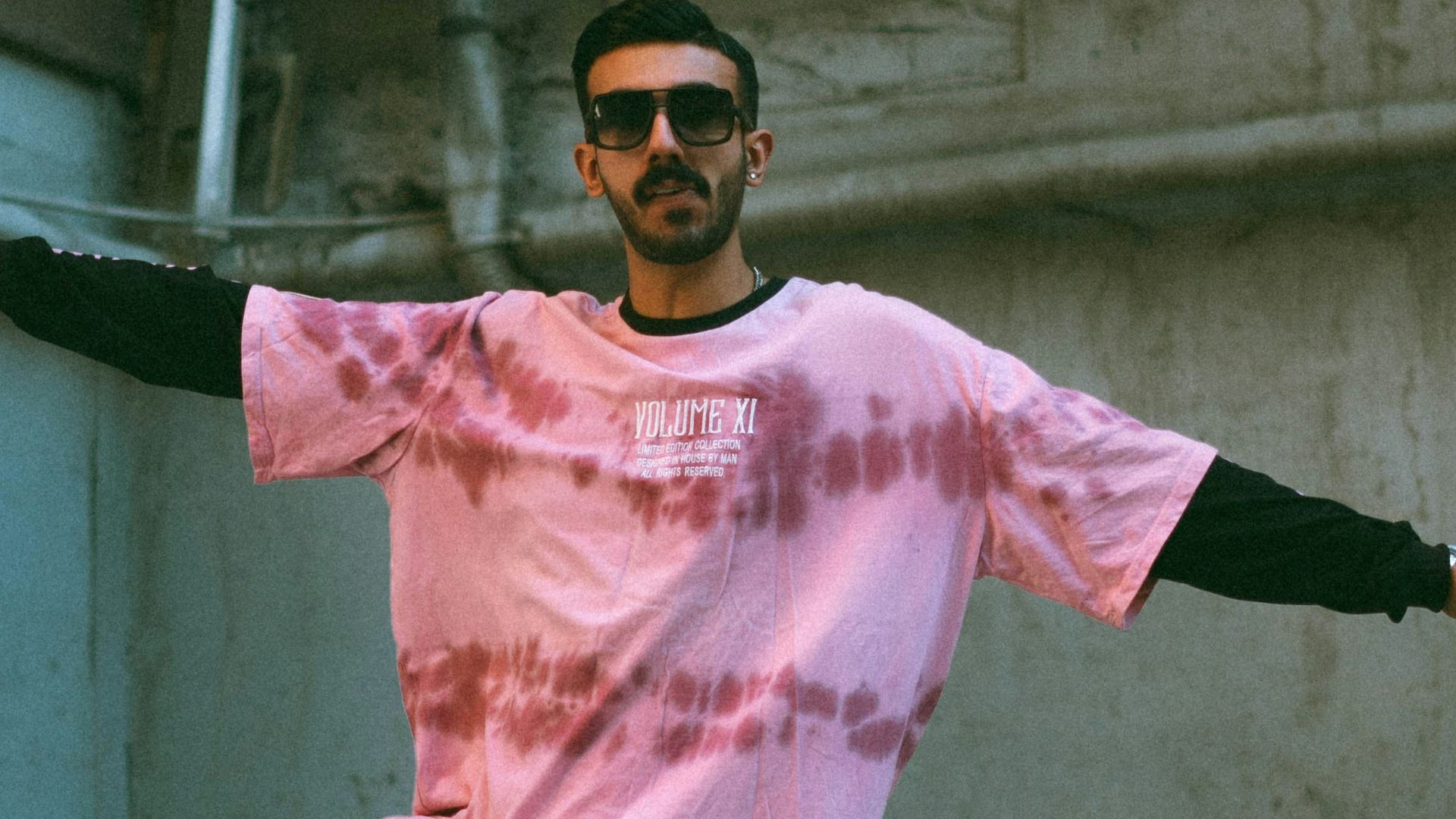 A man in a pink shirt is doing a trick