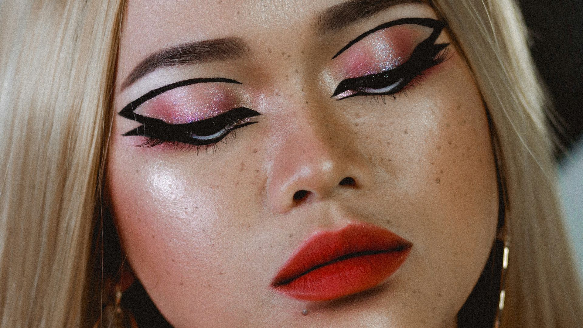 a woman with long blonde hair and red lipstick