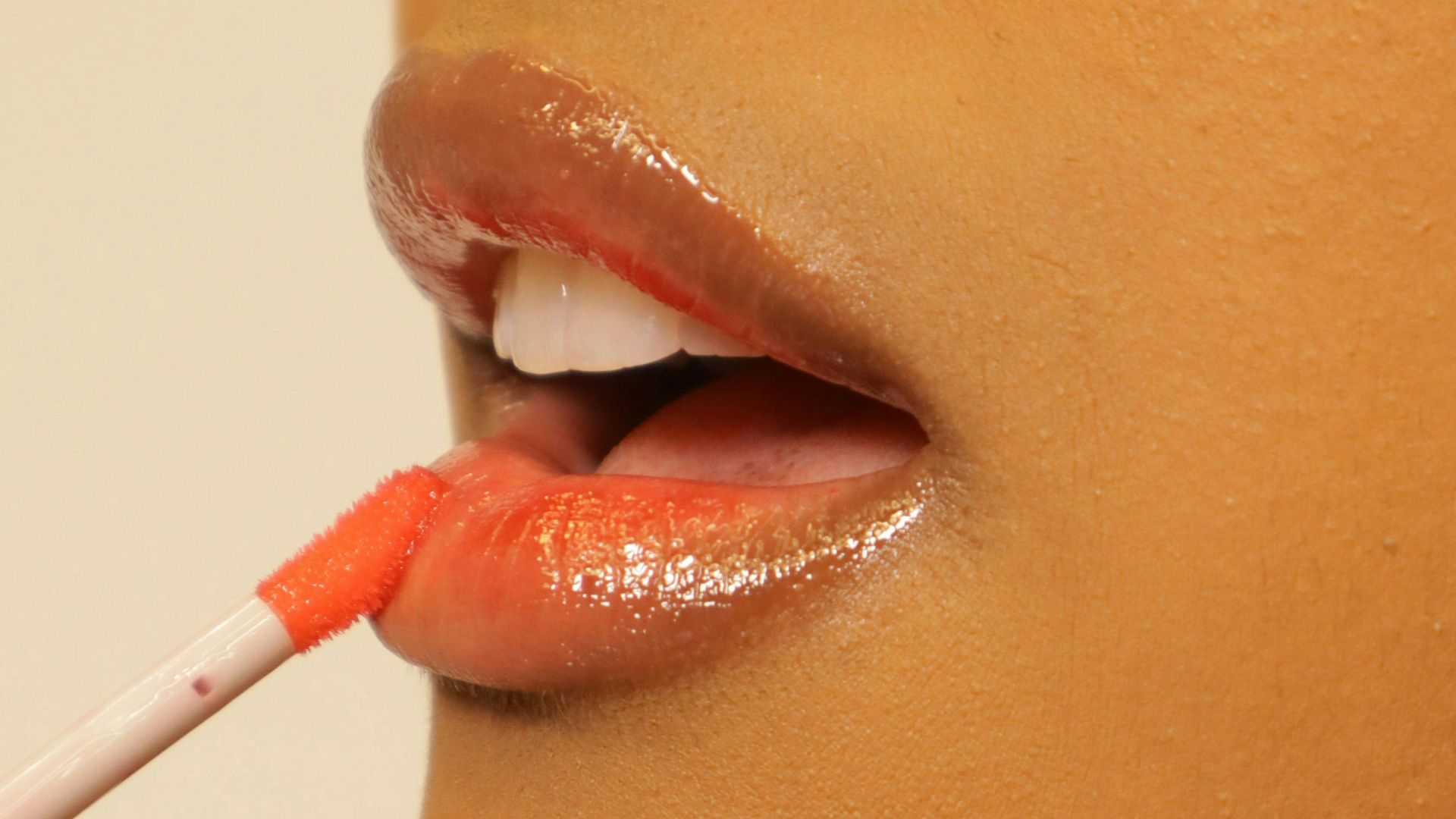 Applying lip gloss to lips.