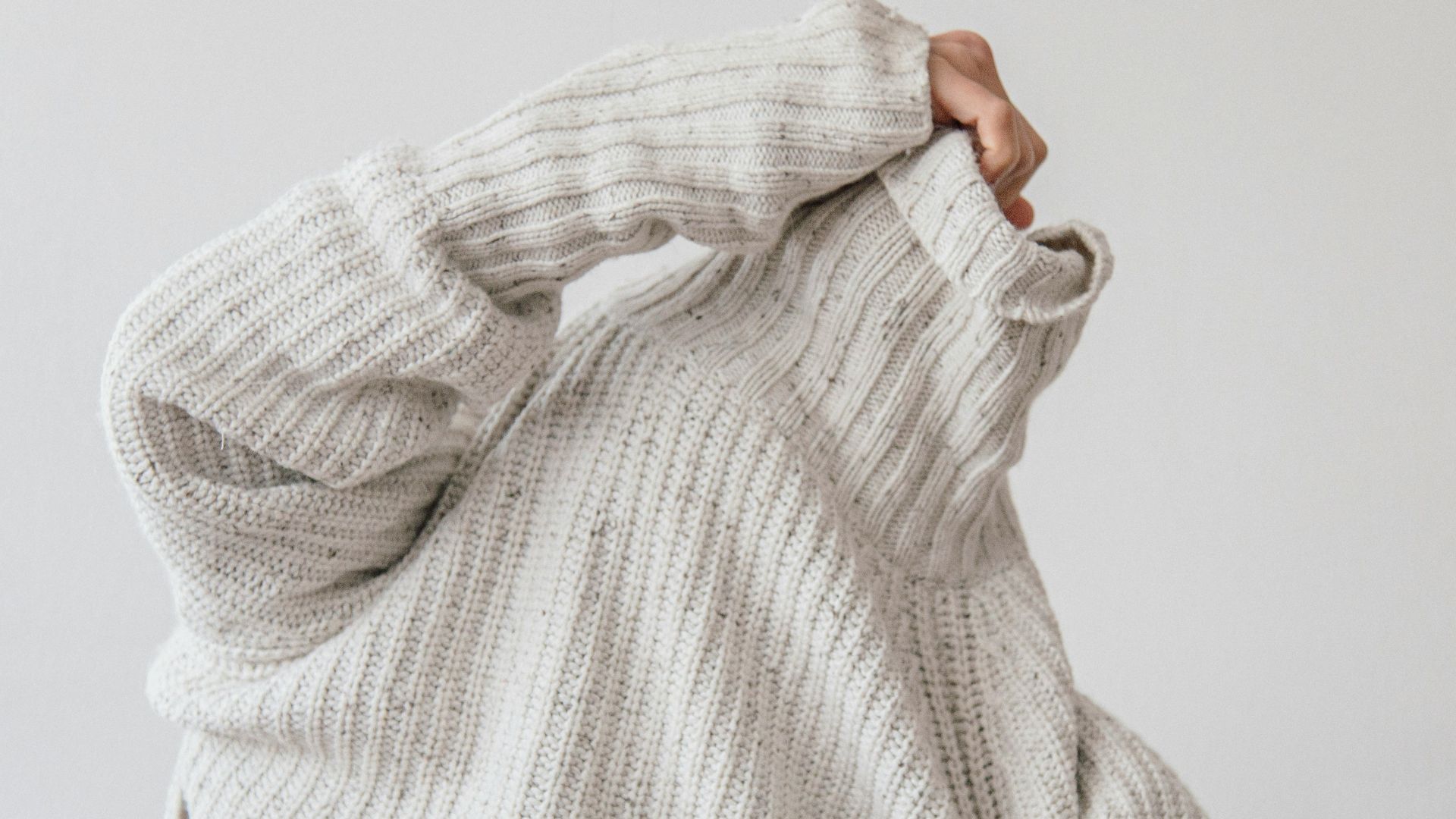 person wearing grey knit sweater