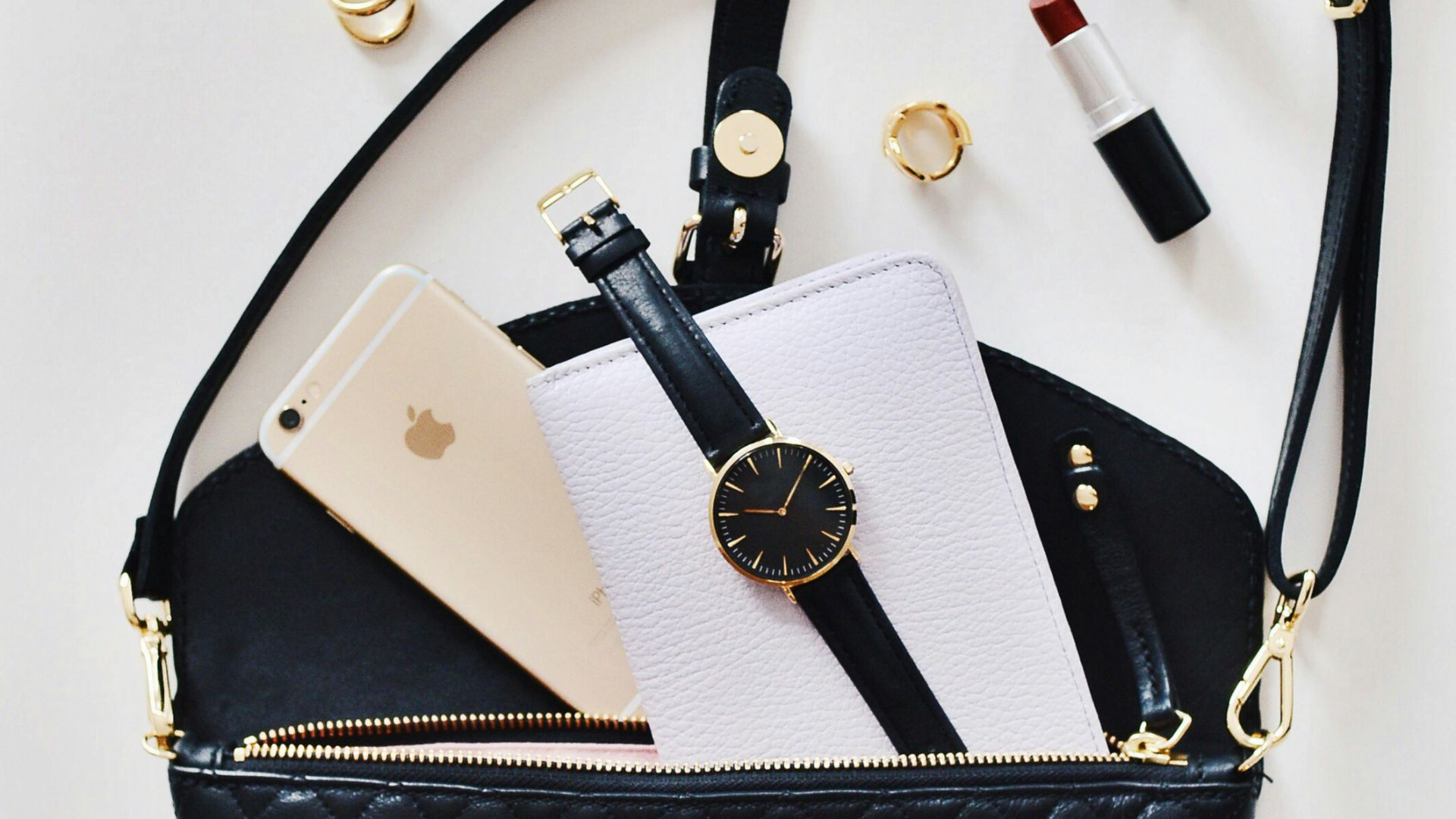 women's sunglasses and black bag with watch and iPhone 6