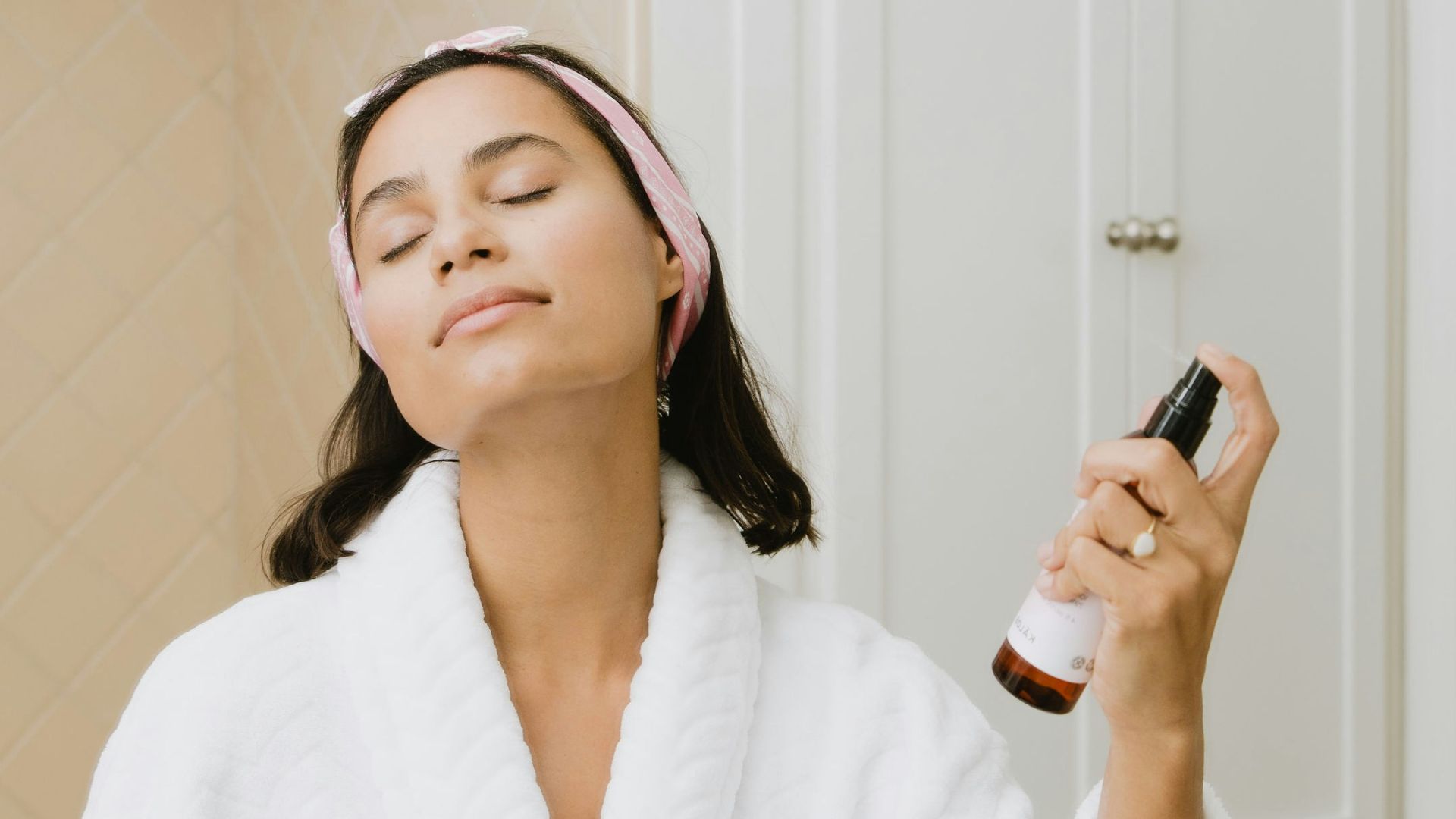 woman in white bathrobe holding smartphone