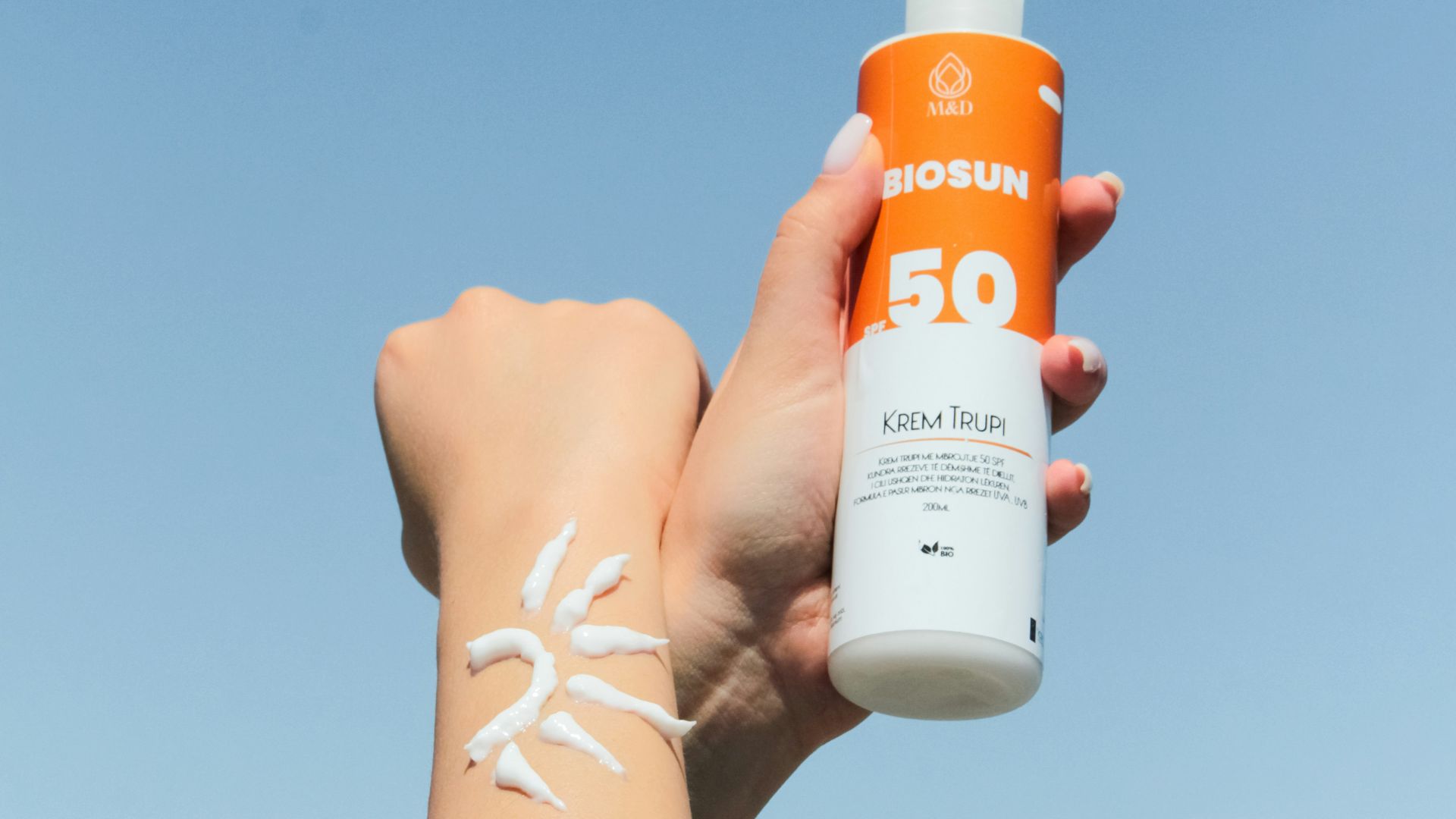 a person holding a bottle of sunscreen in their hand