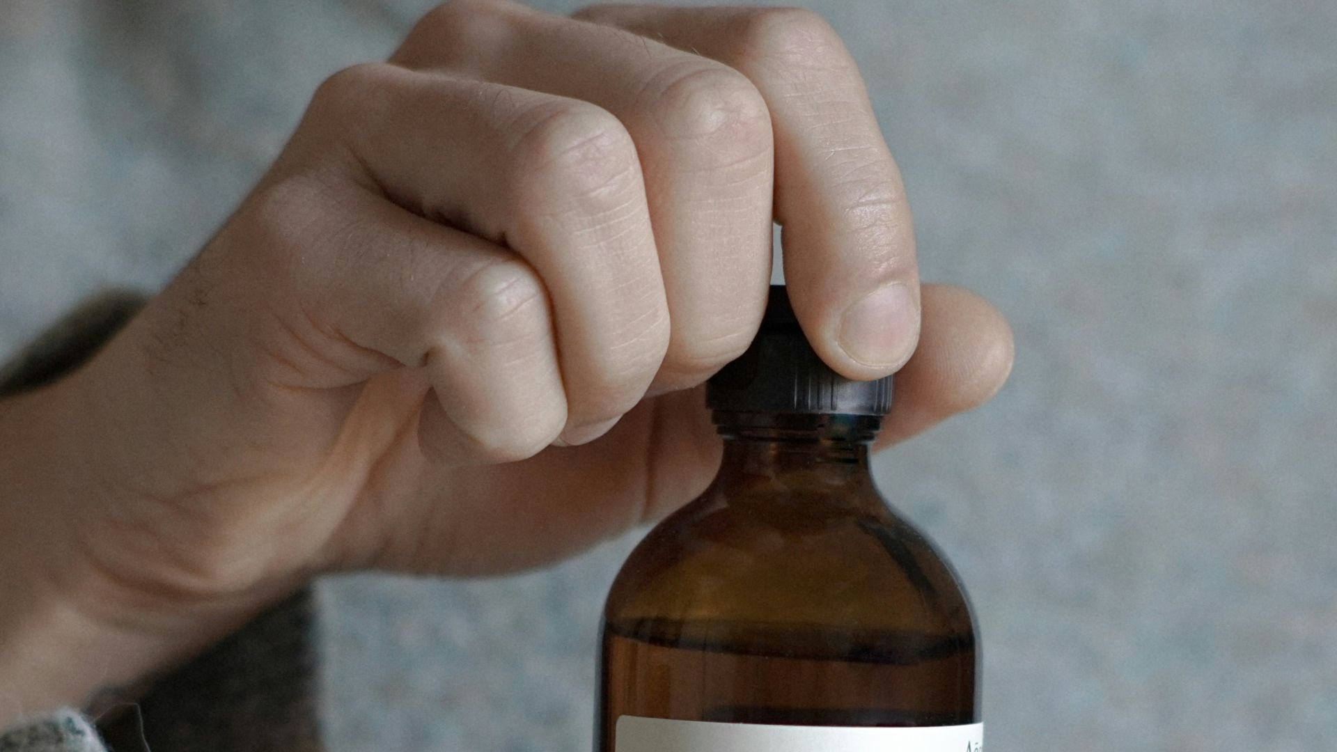 a person holding a bottle of beer in their hand