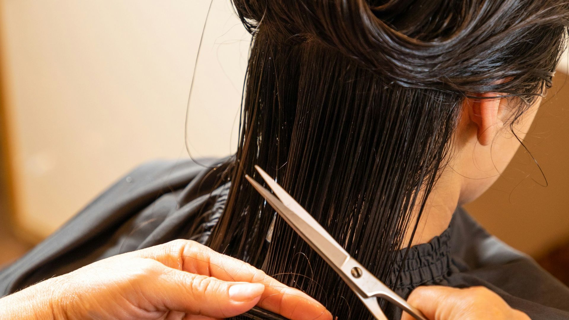 a woman cutting another woman's hair with scissors