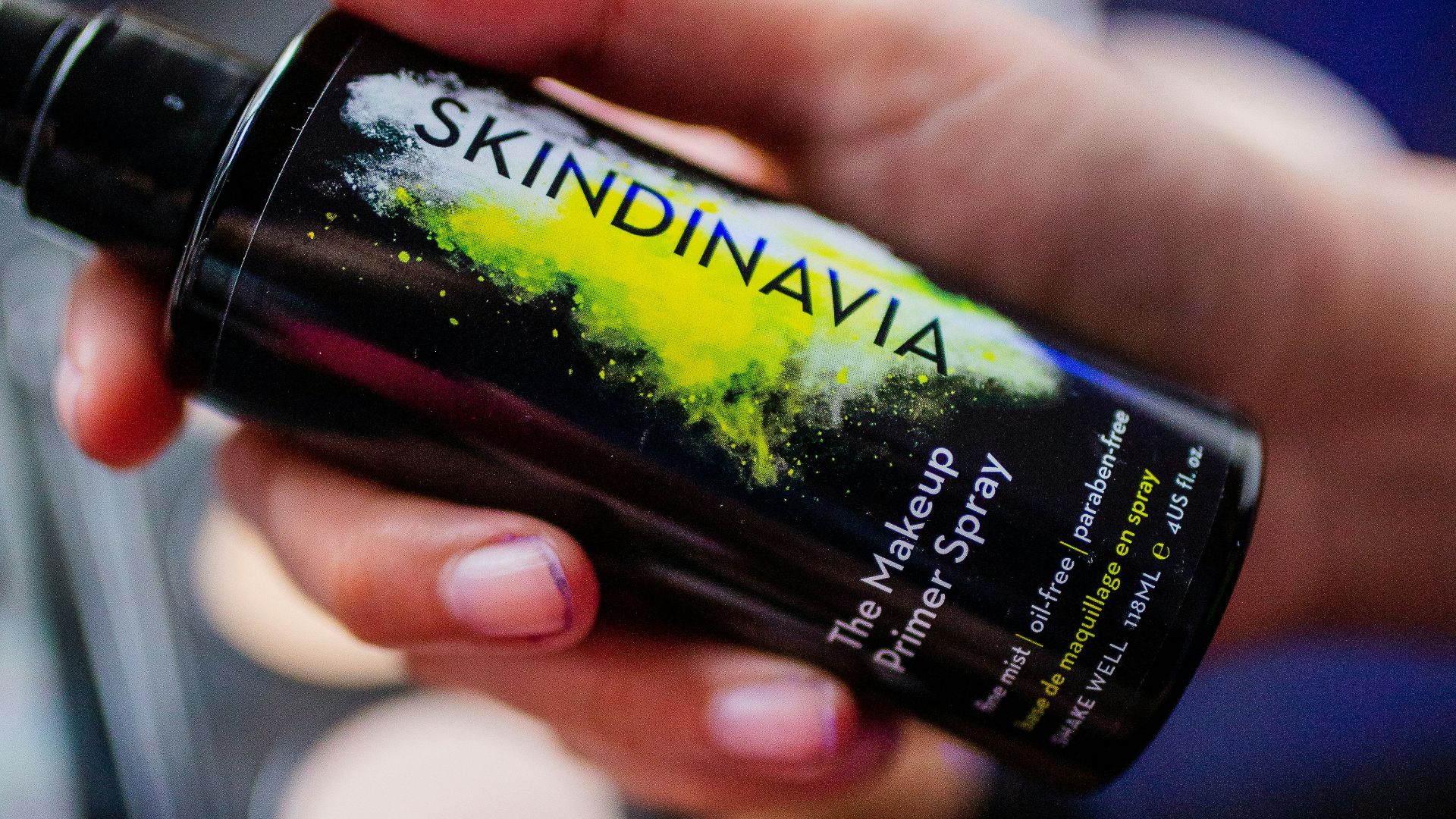 person holding black and green bottle