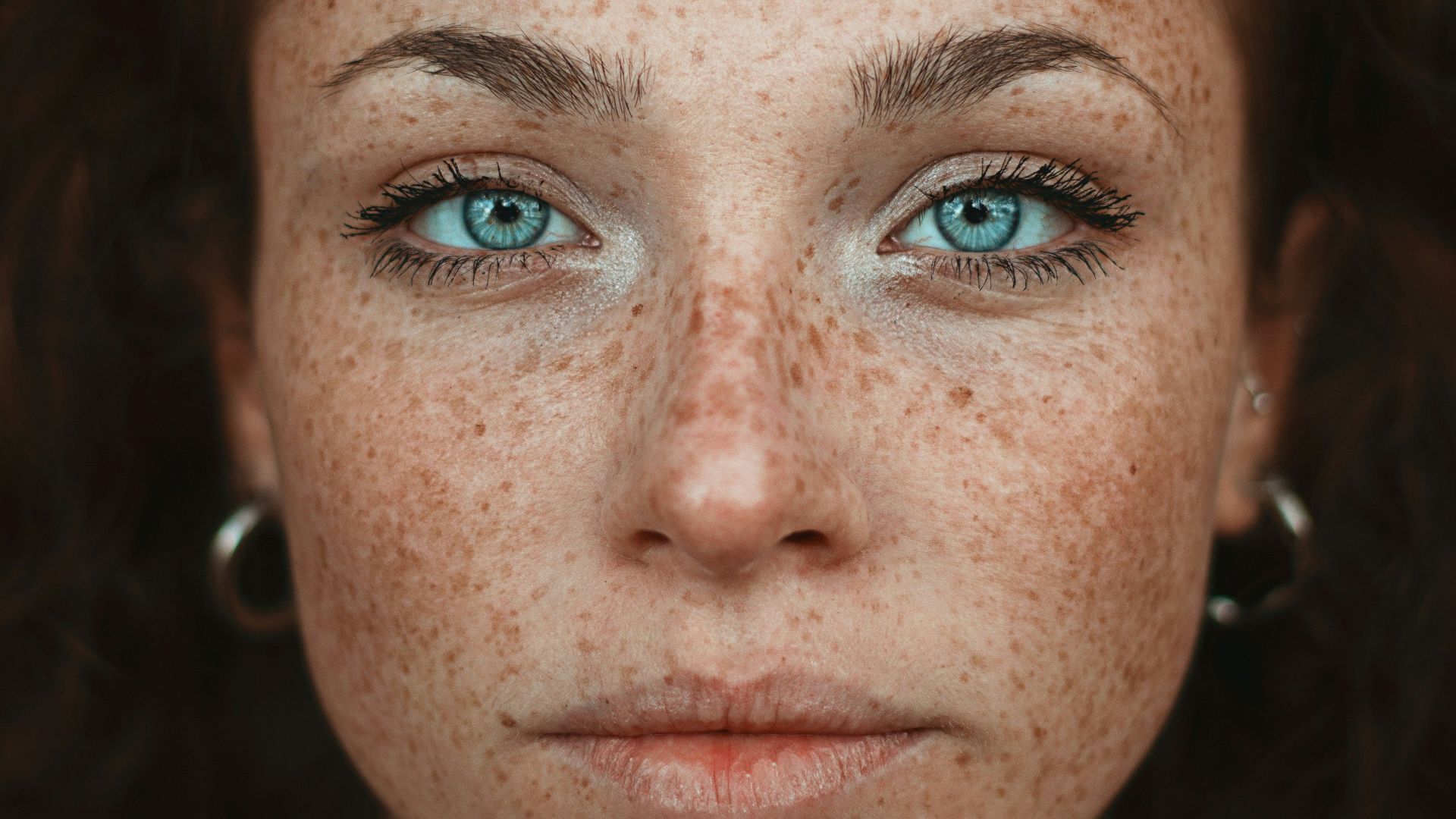 A woman with freckled hair and blue eyes