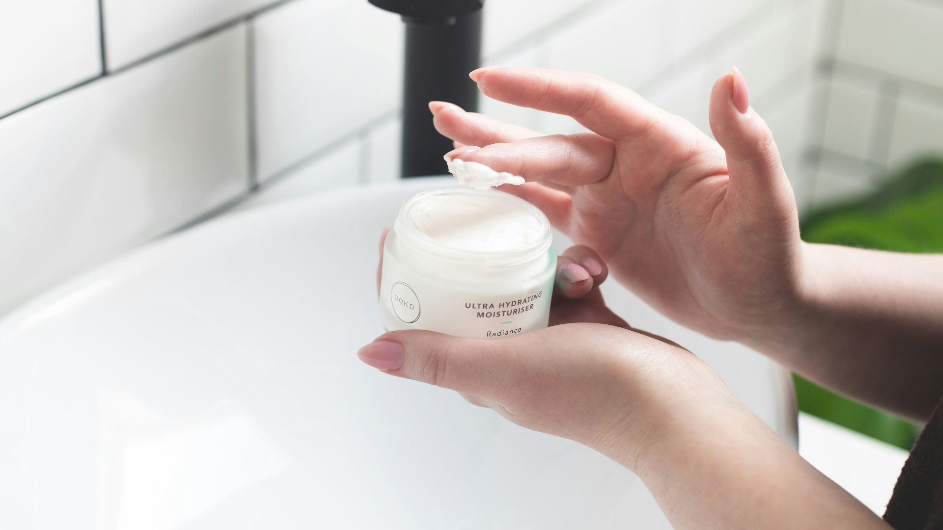 person holding white and black plastic bottle