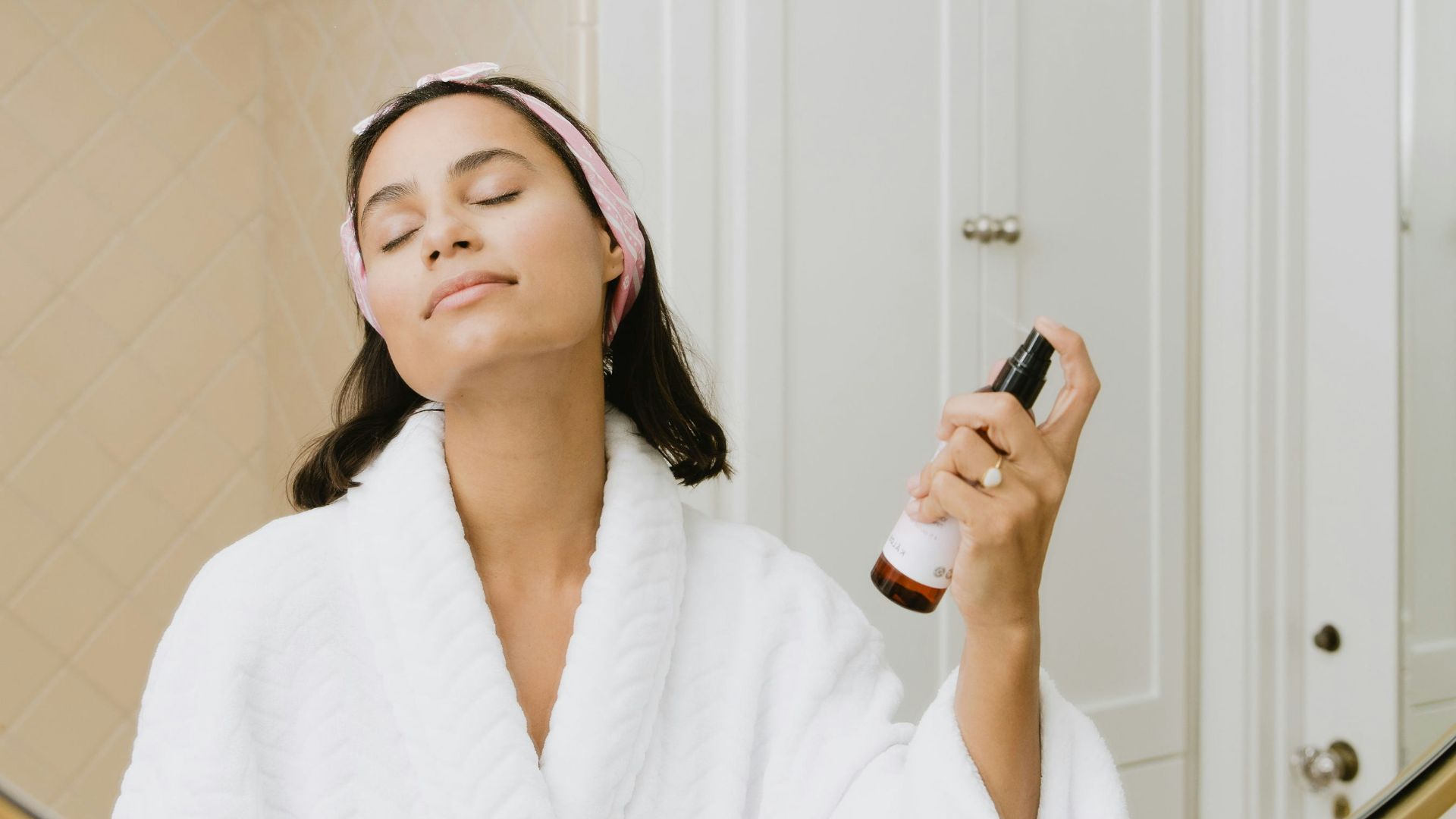 woman in white bathrobe holding smartphone