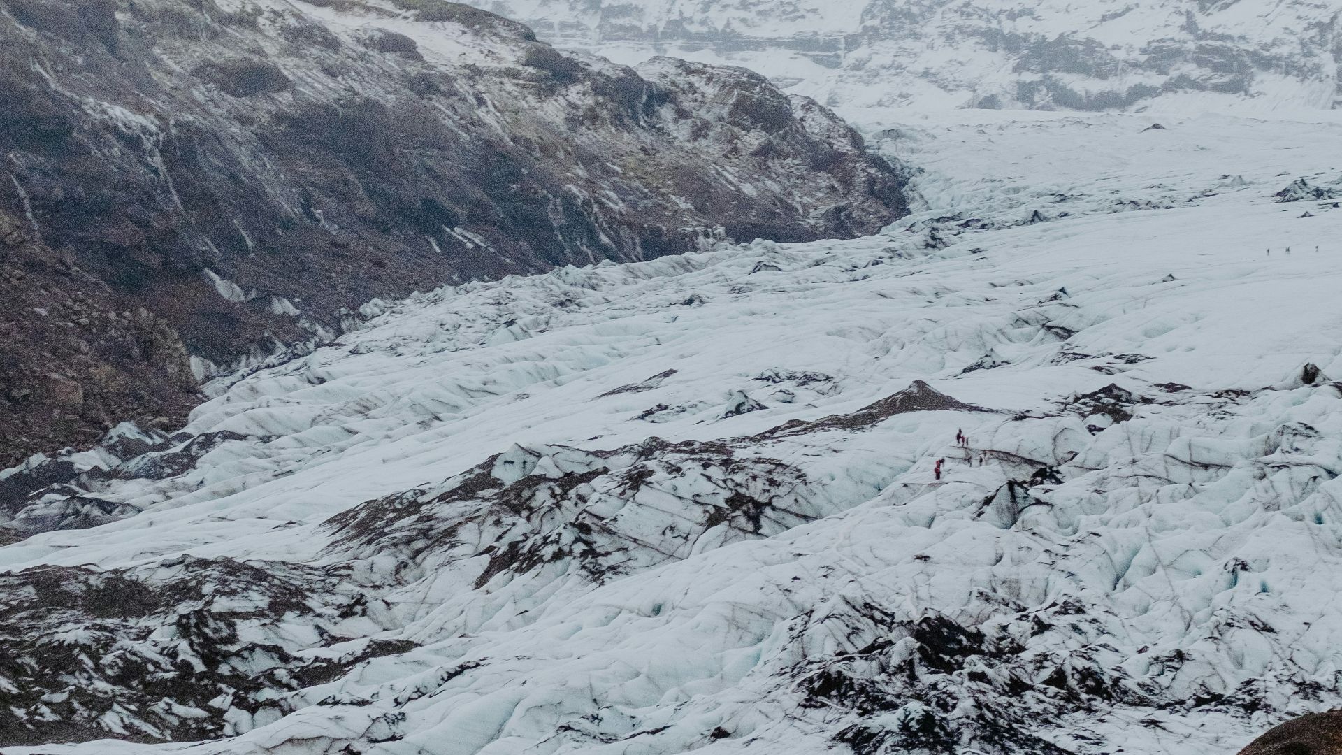 snow covered hills under cloudy sky during daytime