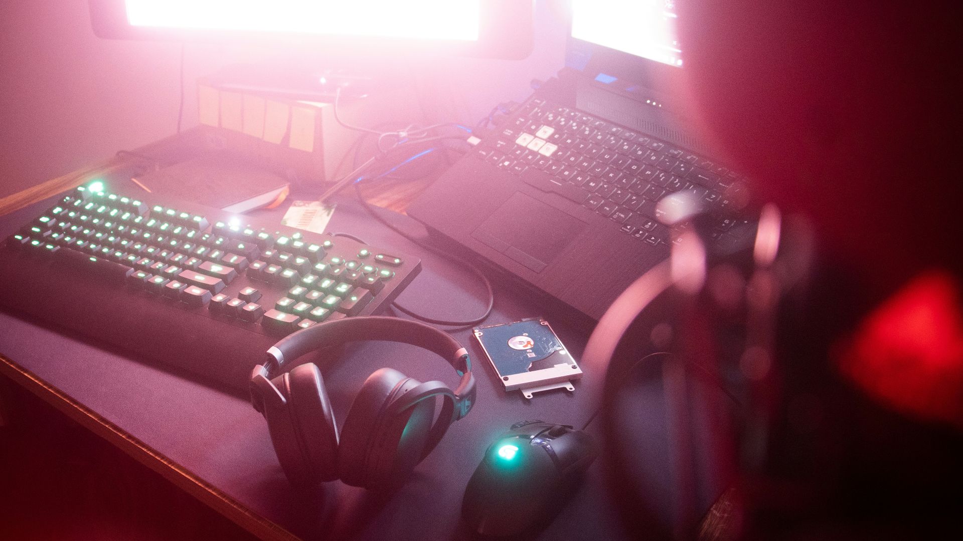 a person holding a remote control in front of a computer