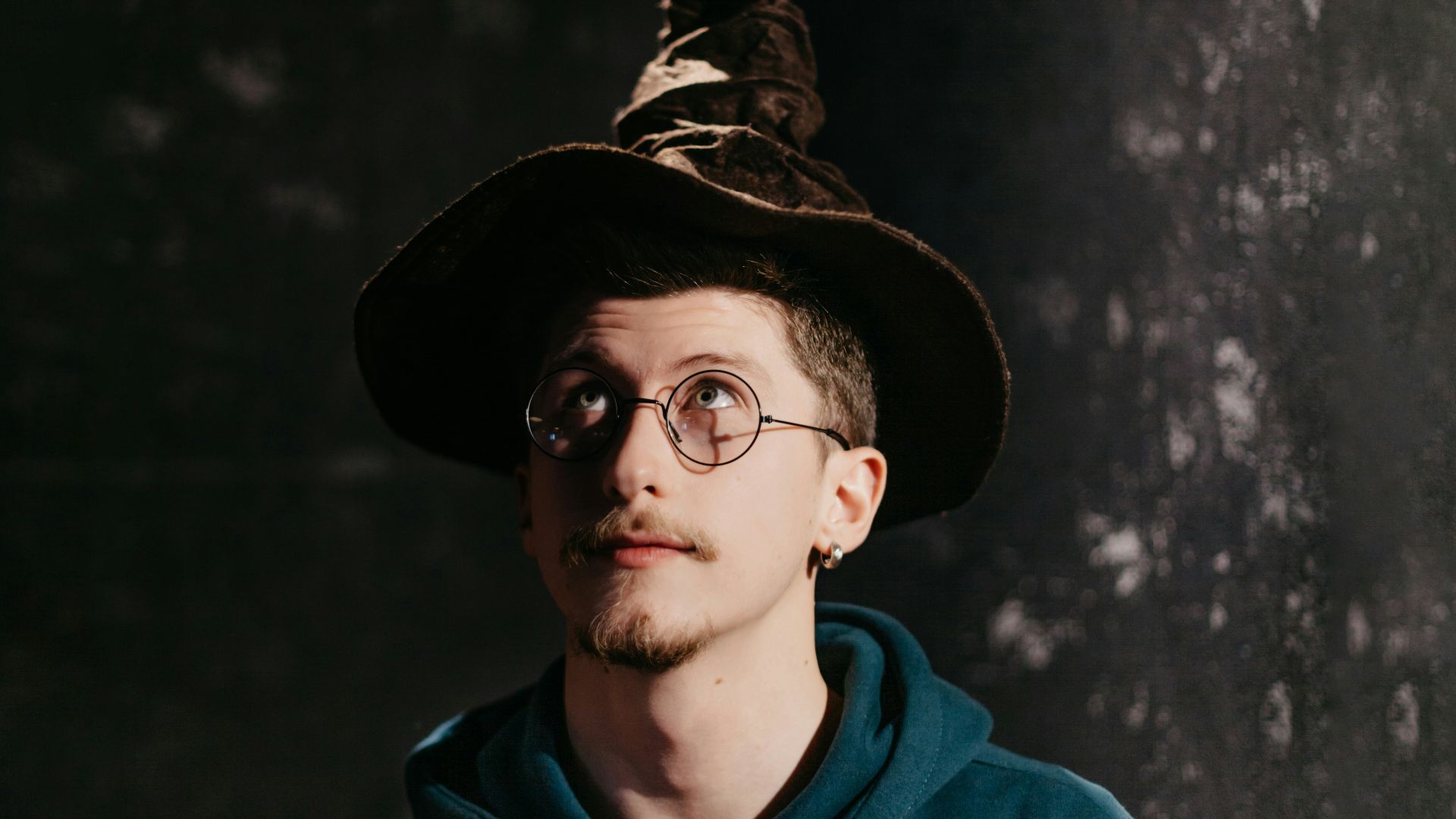 man in blue hoodie wearing black hat