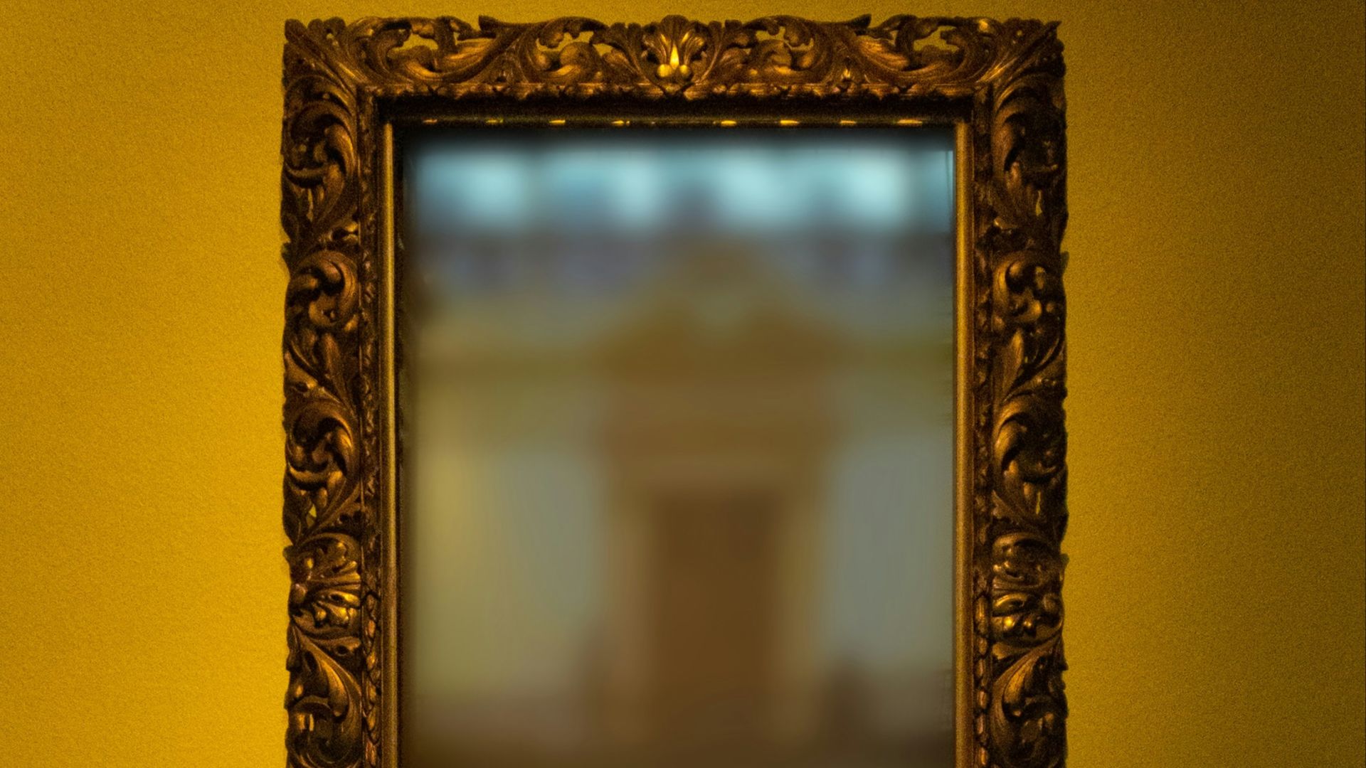 rectangular leaning mirror with brass-colored frame